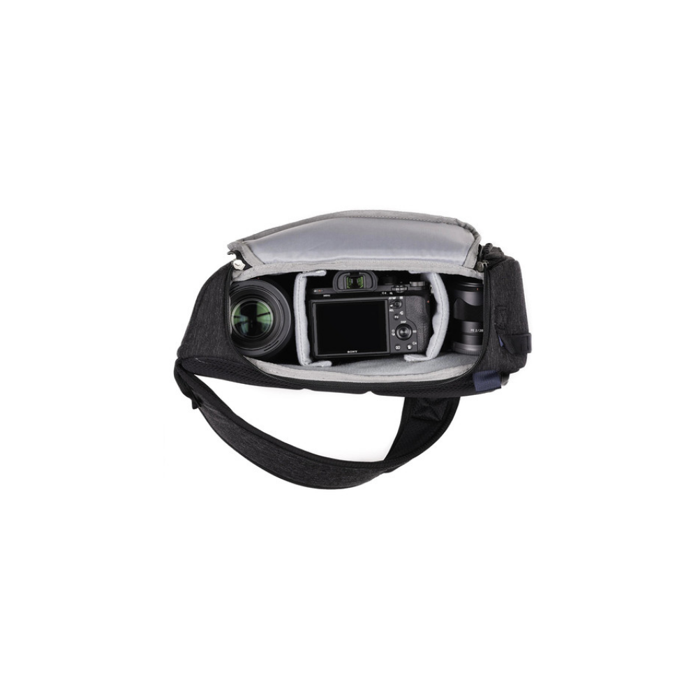 Een zwarte cameratase met een Sony camera en lenzen erin, op witte achtergrond.