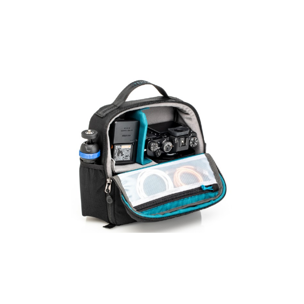 Zwarte cameratas met camera, batterij, statief en kabels erin.