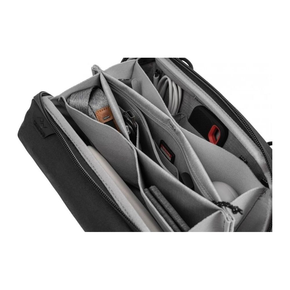 Open grijze tas met meerdere vakken voor kabels en accessoires.