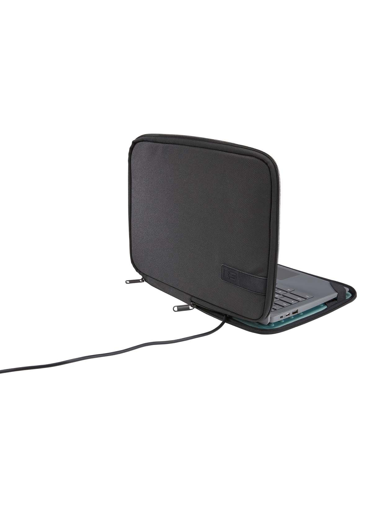 Een zwarte laptop zit half in een zwarte laptoptas, met een uitstekende kabel.