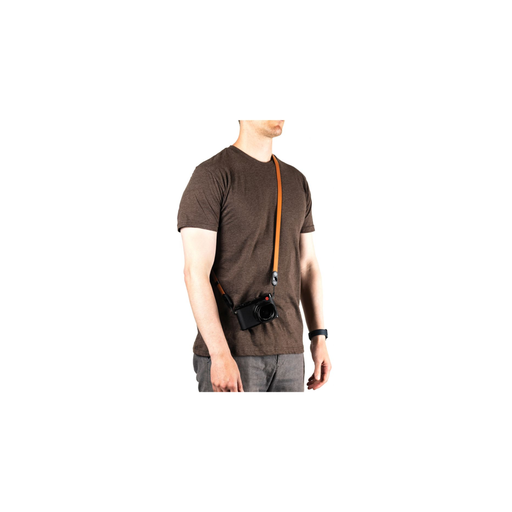 Een man met een bruin t-shirt en een camerariem om zijn nek.