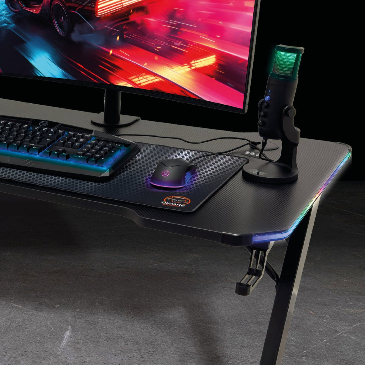Ein Gaming-Schreibtisch mit Tastatur, Maus, Mikrofon und beleuchtetem Monitor.