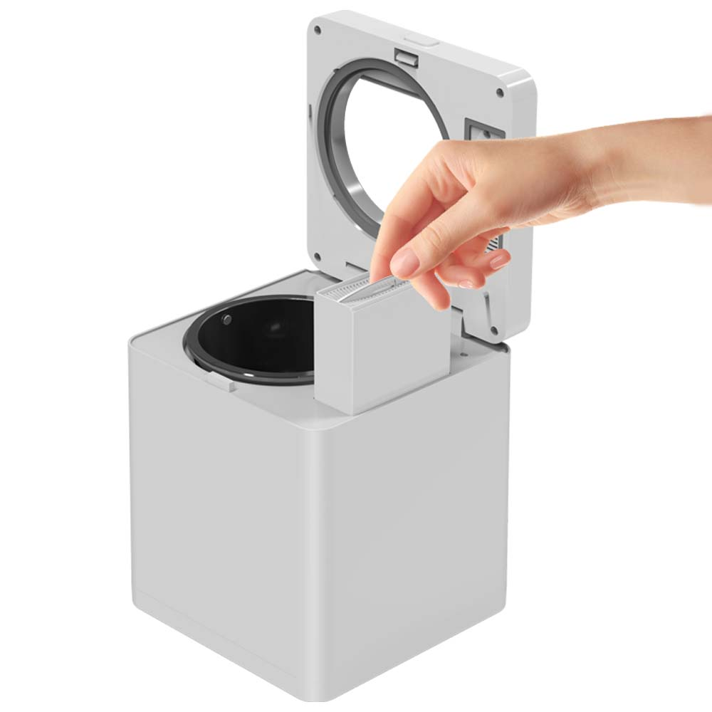 Una mano inserisce un filtro bianco in un apparecchio bianco aperto.