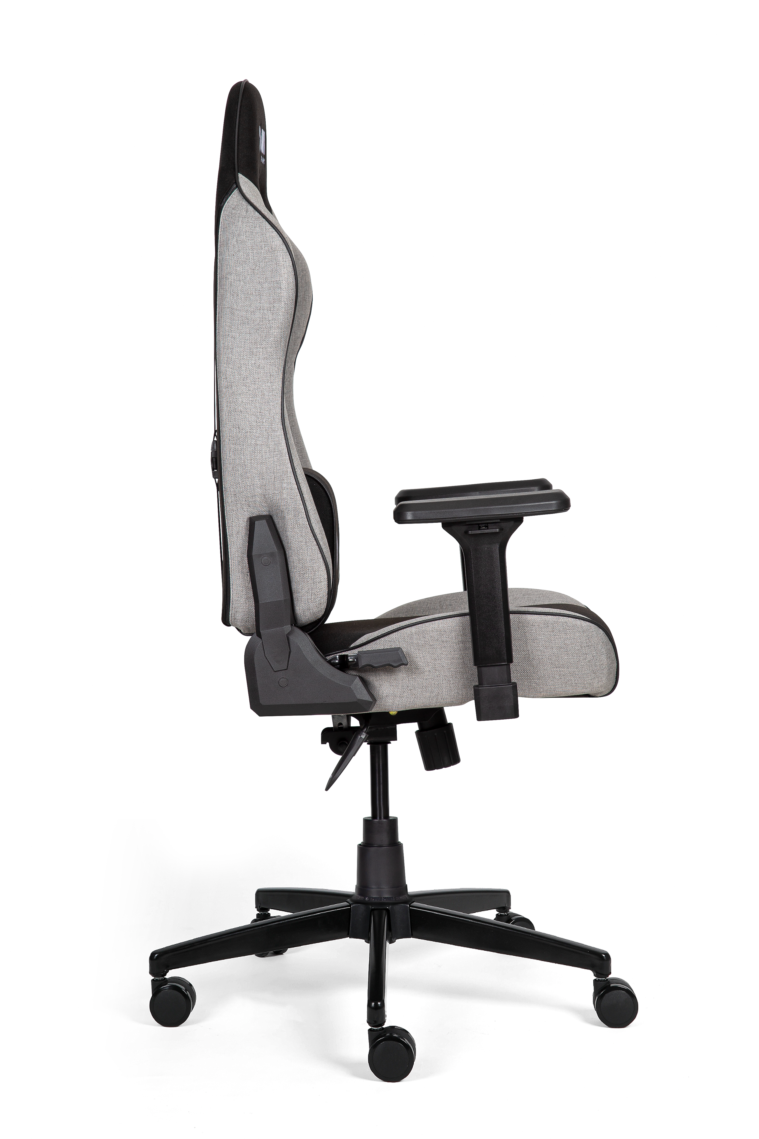 Beyaz arka plan üzerinde yandan görünen, siyah detaylı gri kumaş ergonomik oyuncu koltuğu.