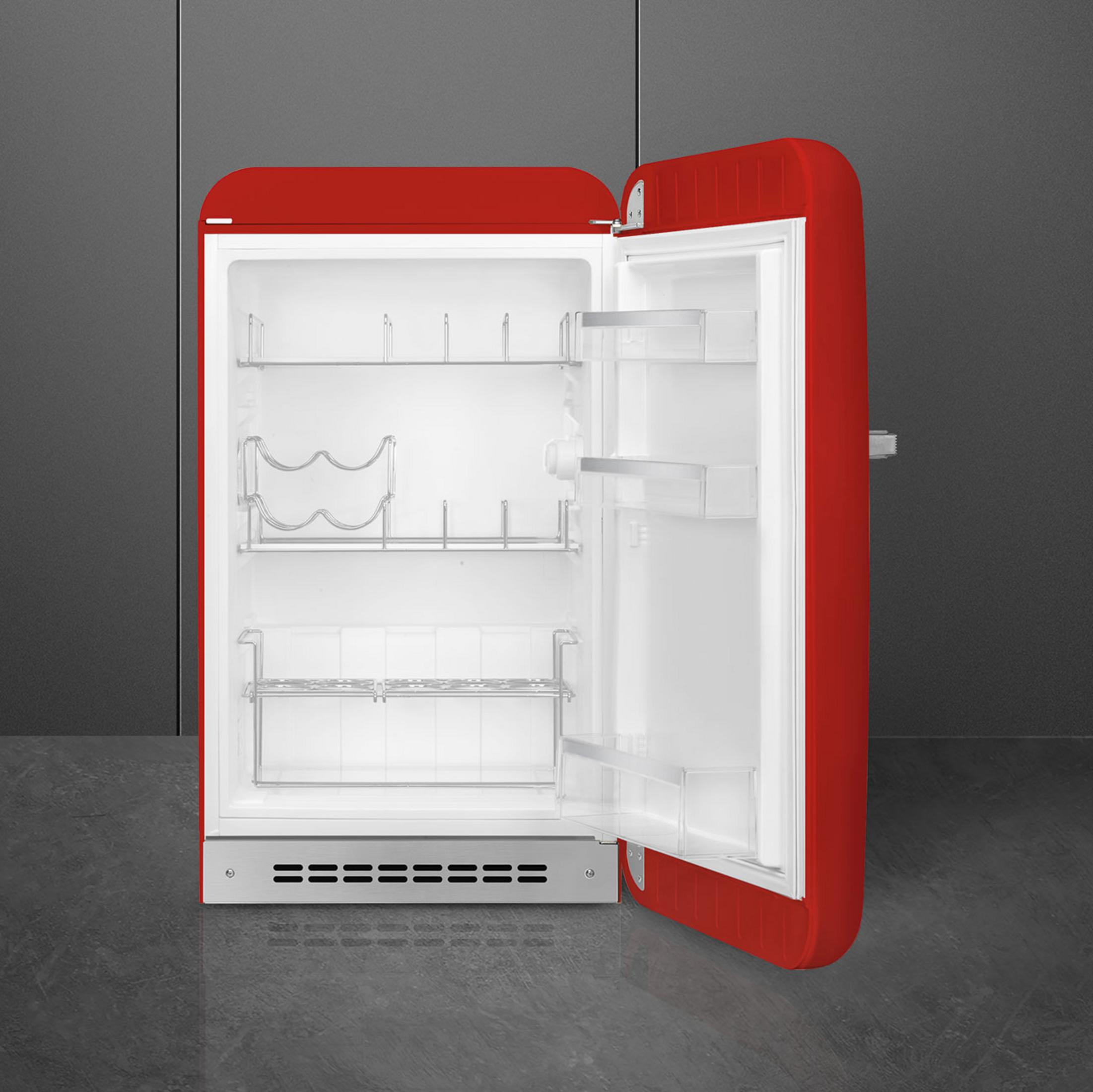Un refrigerador rojo con la puerta abierta, vacío por dentro con estantes.
