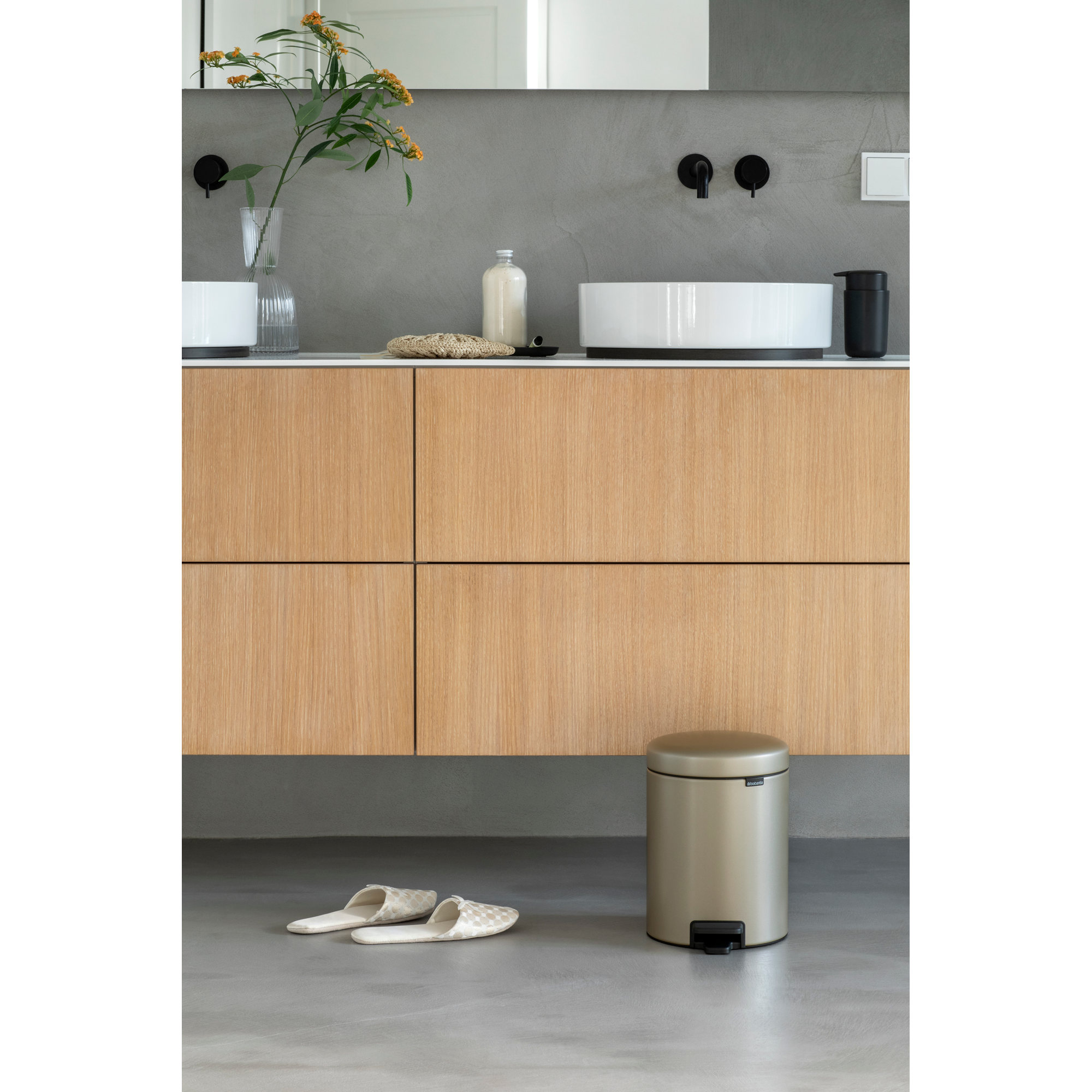Moderne badkamer met houten meubel, wastafel en prullenbak.