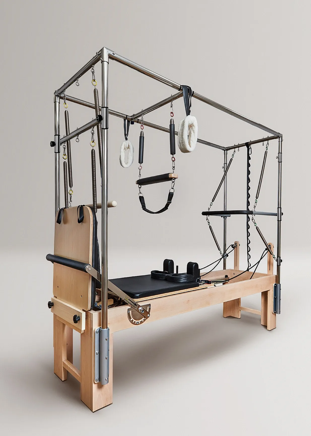 Reformador de pilates de madera con marco de metal, resortes y asas.