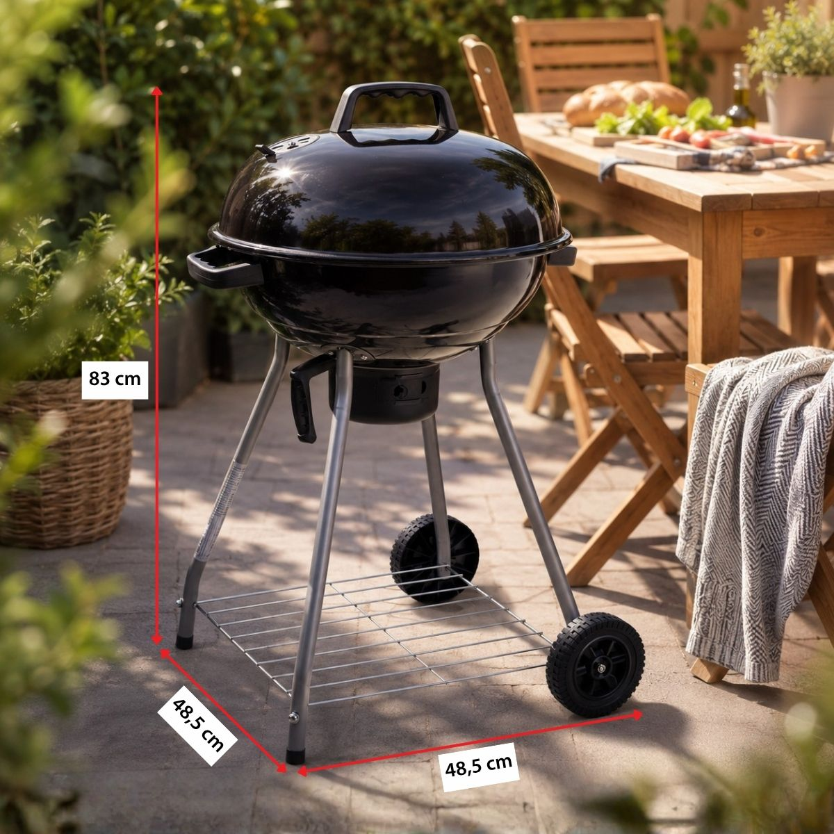 A black kettle grill with a round lid on a metal stand with wheels.
