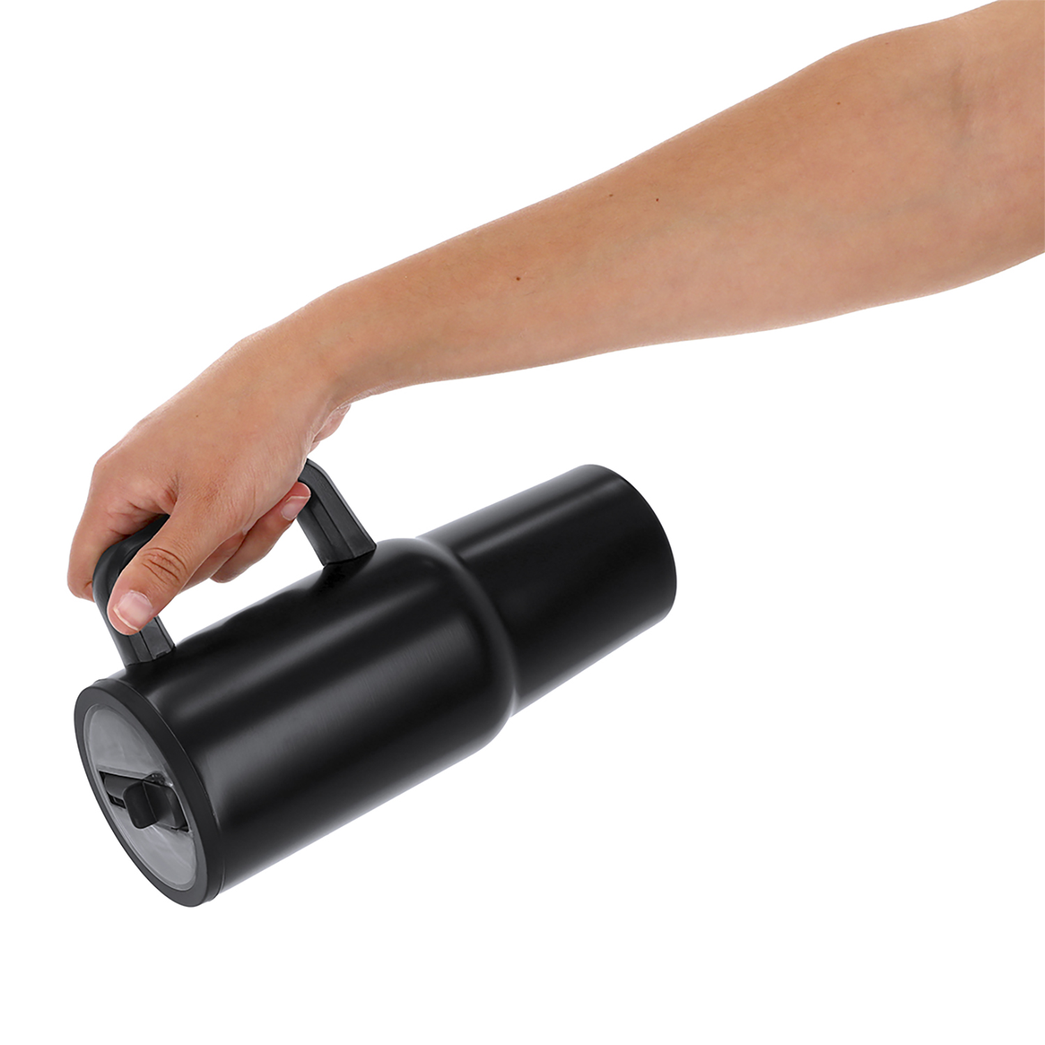 Una mano sostiene un vaso negro con asa.
