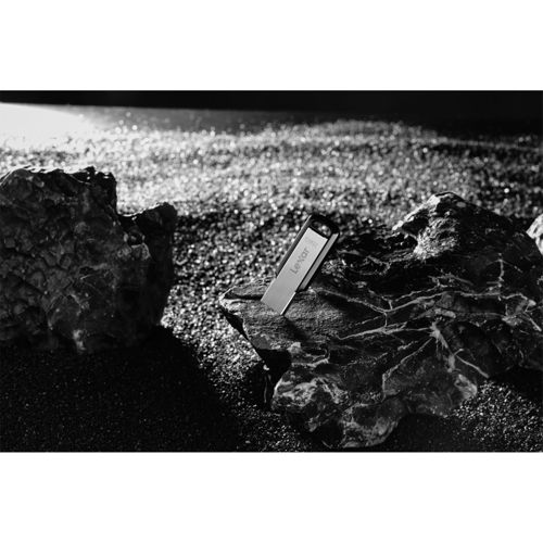 Un'unità USB Lexar è conficcata in una roccia su un terreno roccioso e sabbioso.