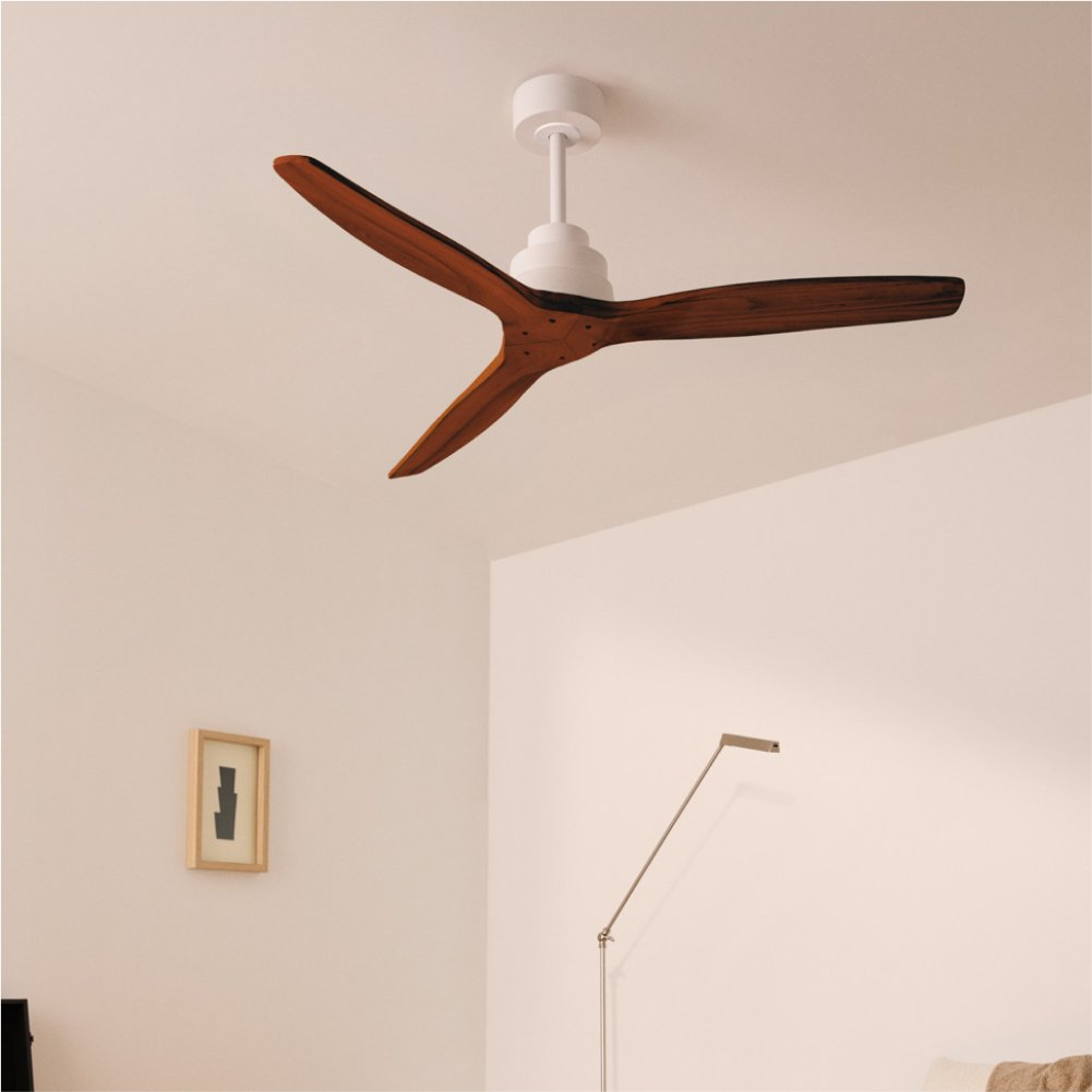 Un moderno ventilador de techo blanco con aspas de madera oscura cuelga de un techo blanco.