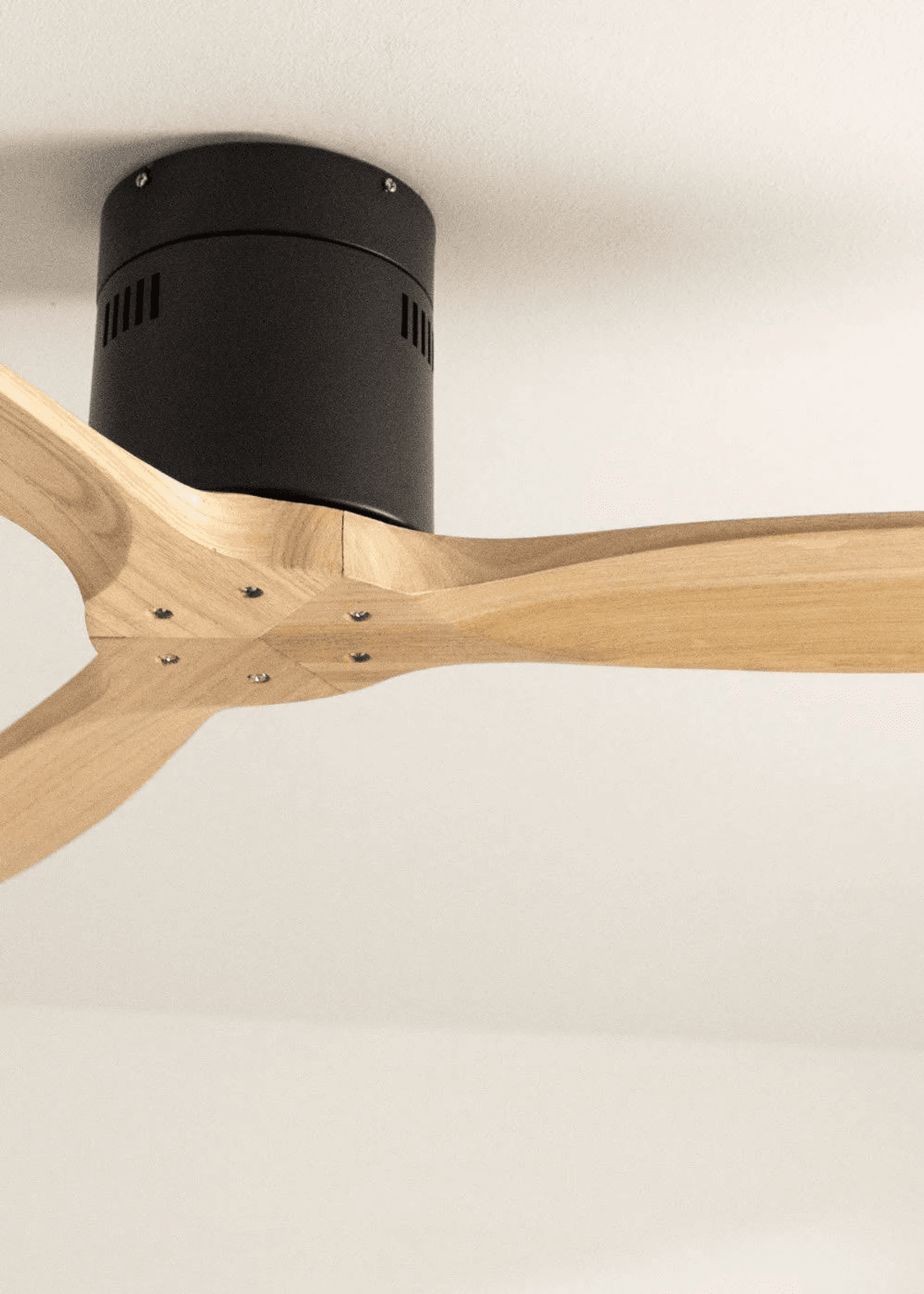 Ventilador de techo moderno con carcasa negra y aspas de madera, primer plano.