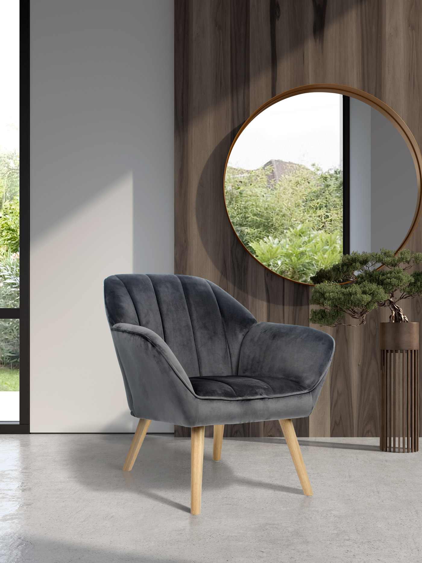 Un sillón de terciopelo gris con patas de madera frente a pared de madera y espejo.