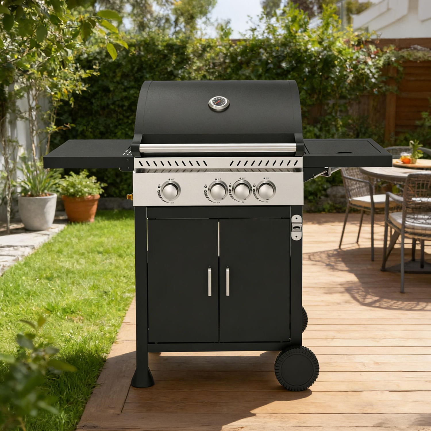 Una parrilla negra está en una terraza de madera en un jardín.