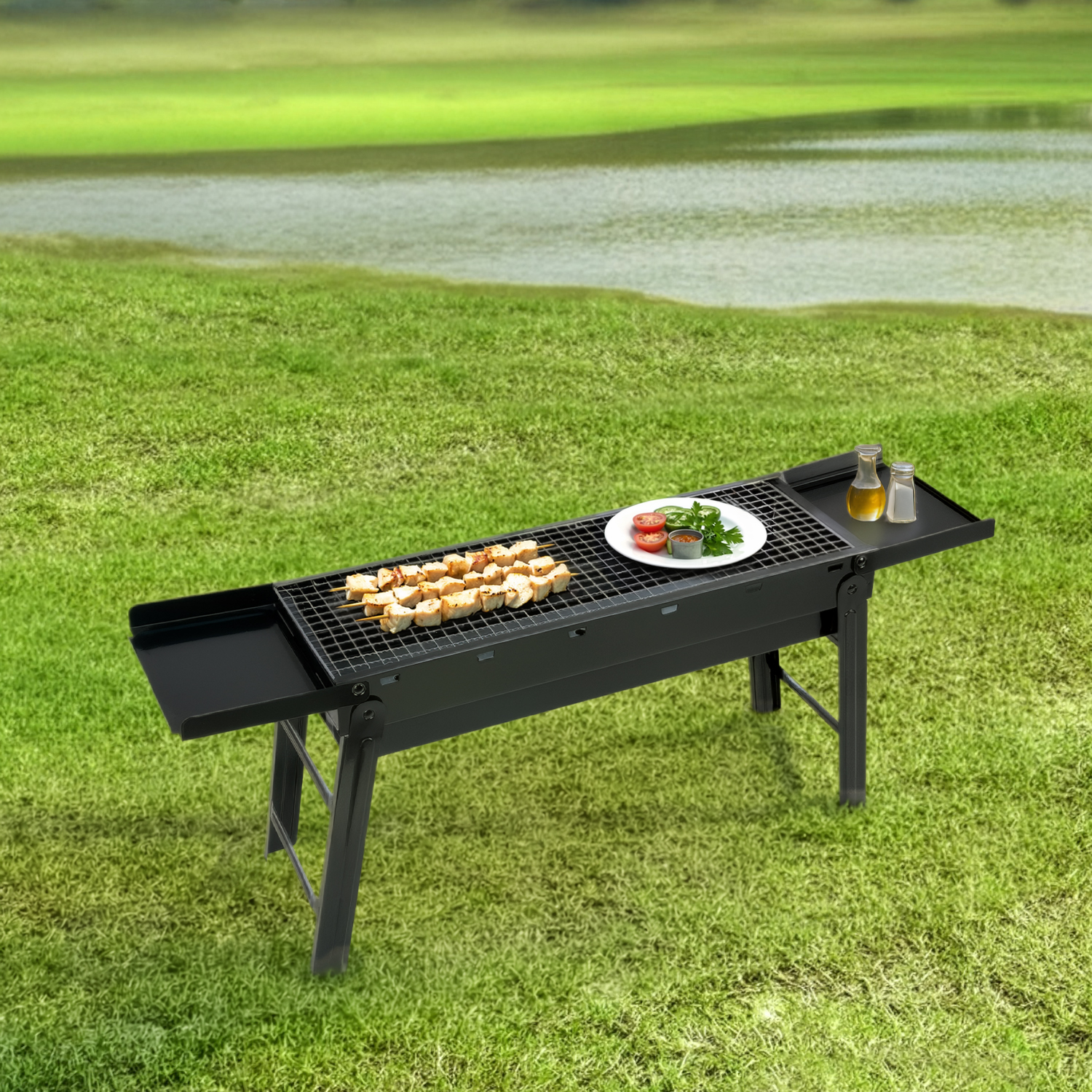 Una parrilla negra con brochetas de carne y guarniciones en un césped verde junto al agua.