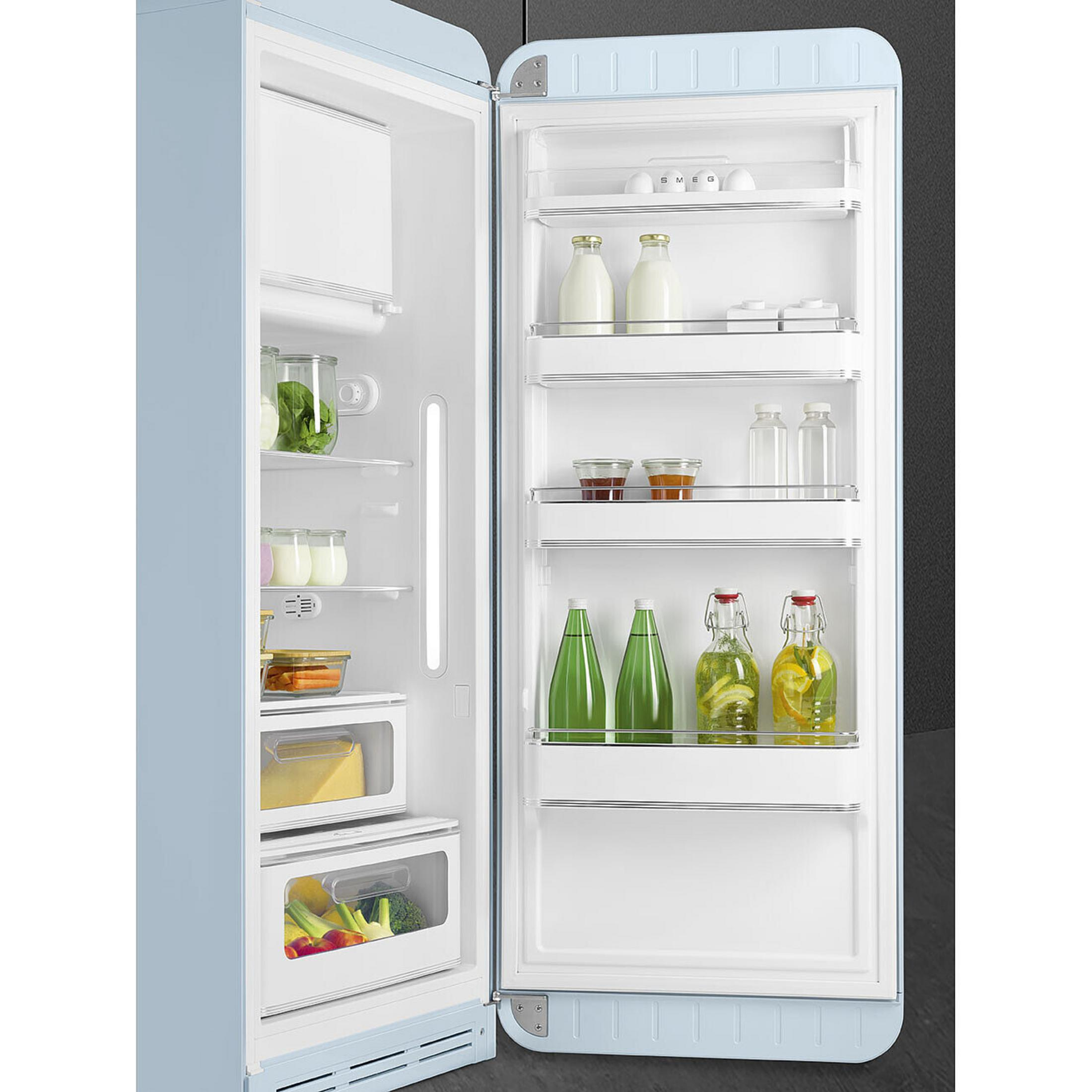 Un refrigerador azul claro está abierto. Las estanterías contienen leche, huevos, mermelada, agua y verduras.
