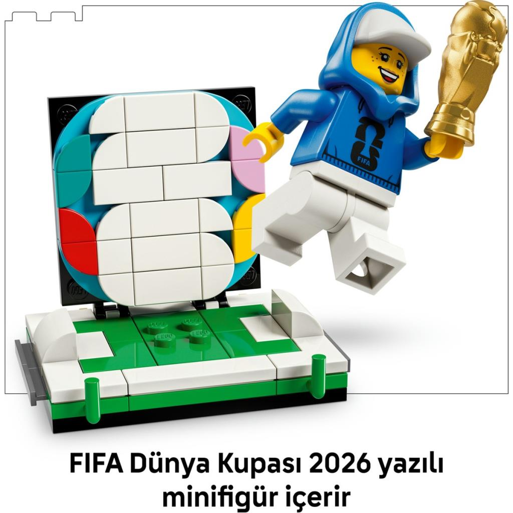 Piłkarz Lego z pucharem skacze na ekspozycji boiska piłkarskiego.
