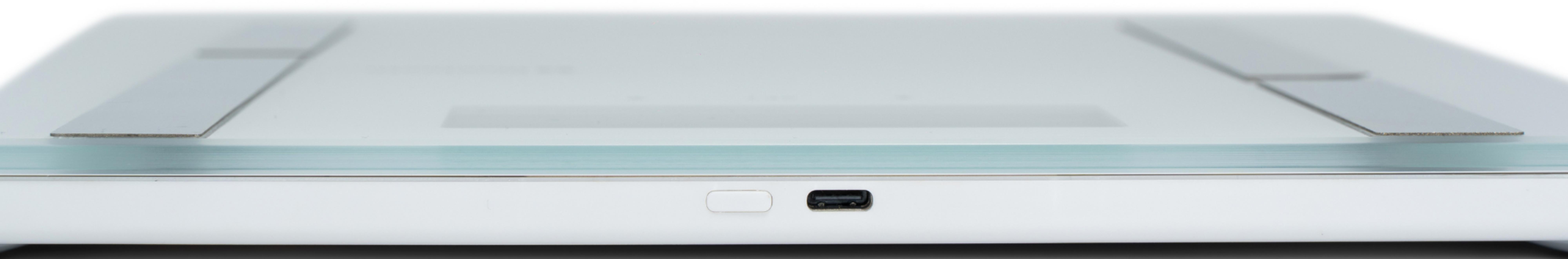 Biała waga cyfrowa ze szklanym blatem i srebrnymi detalami, widoczny port USB.