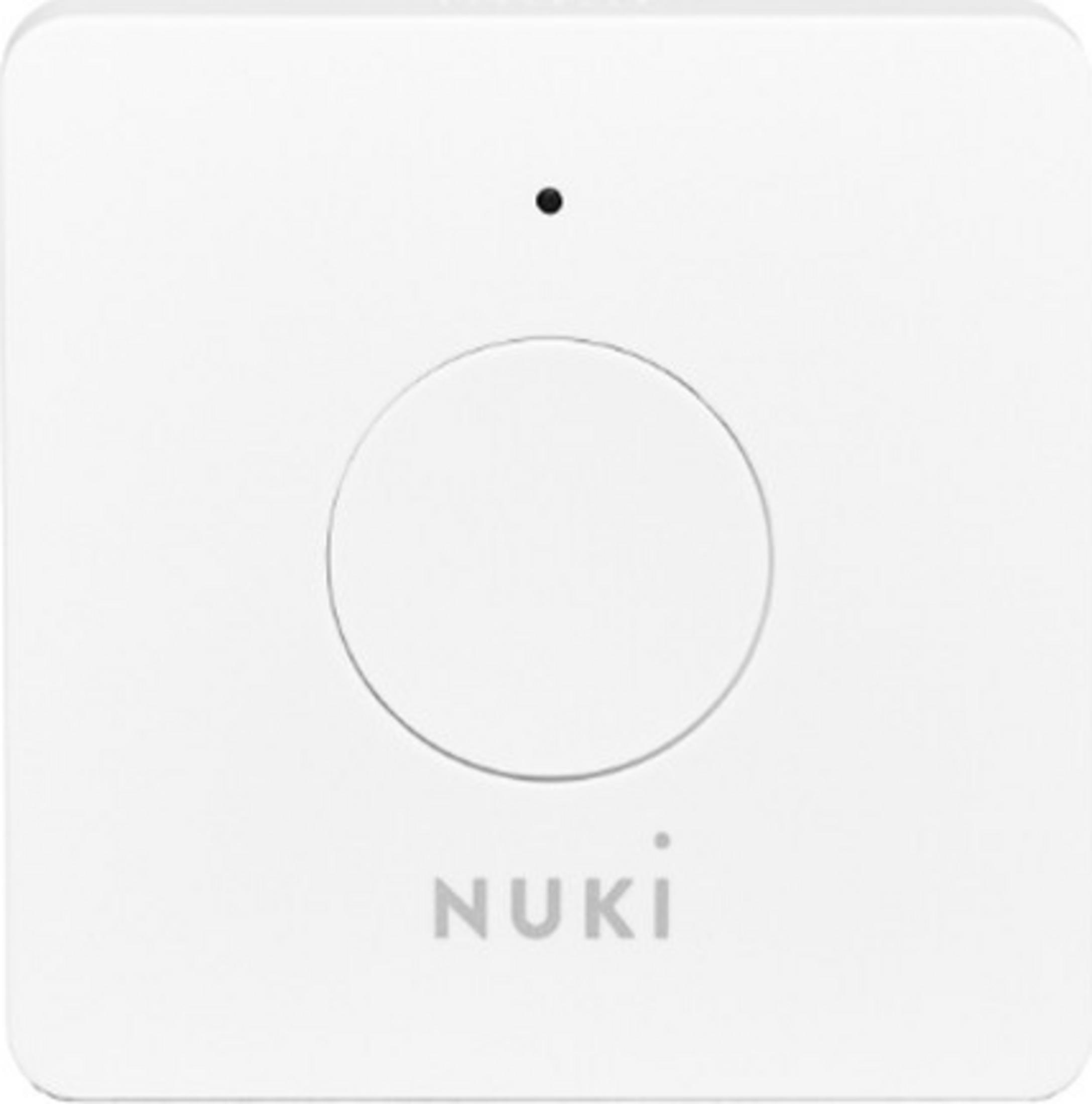 Un appareil carré blanc avec un cercle et le logo Nuki.