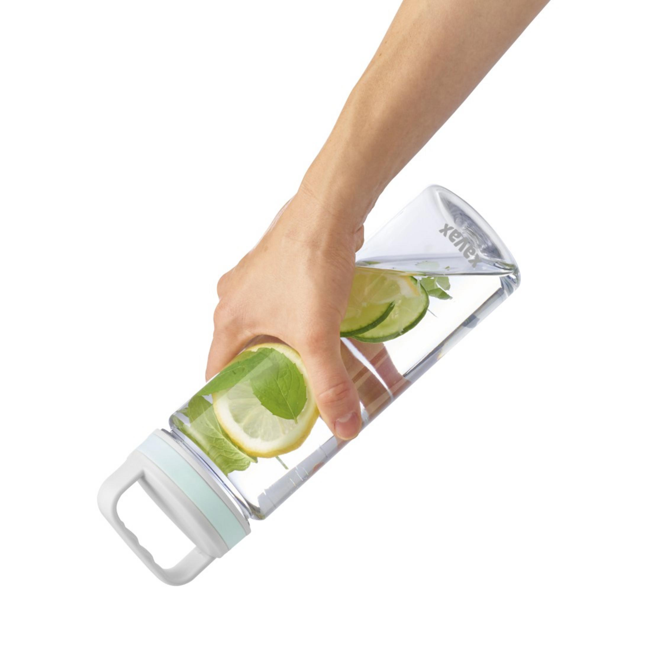 Eine Hand hält eine Glasflasche mit Wasser, Zitrone, Limette und Minze.