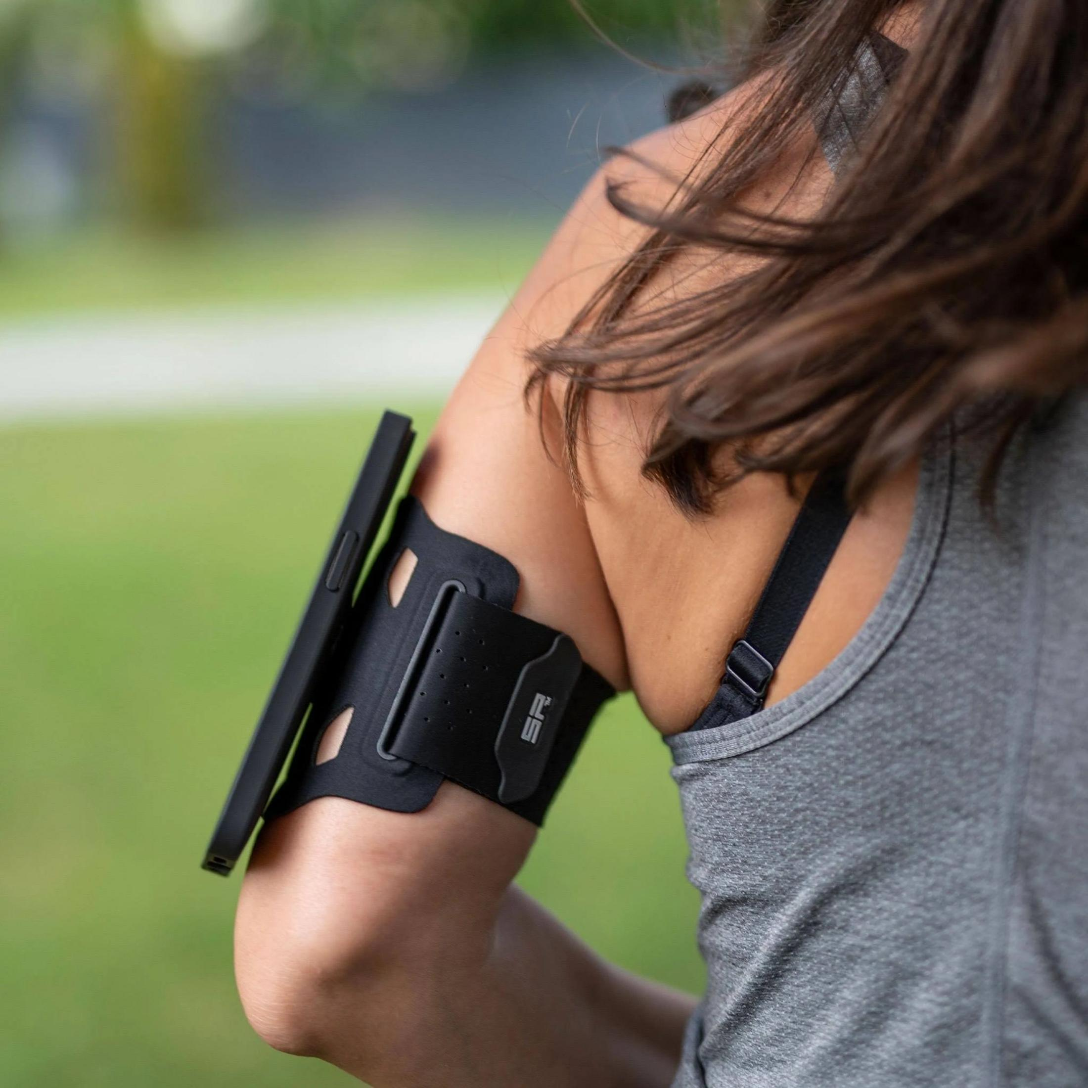 Eine Person trägt ein schwarzes Handy-Armband am Oberarm.