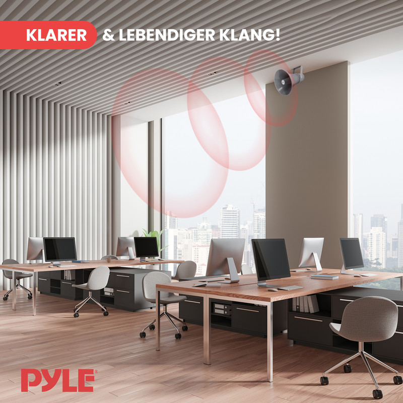 Ein Büro mit Schreibtischen, Computern und einem Lautsprecher an der Decke.