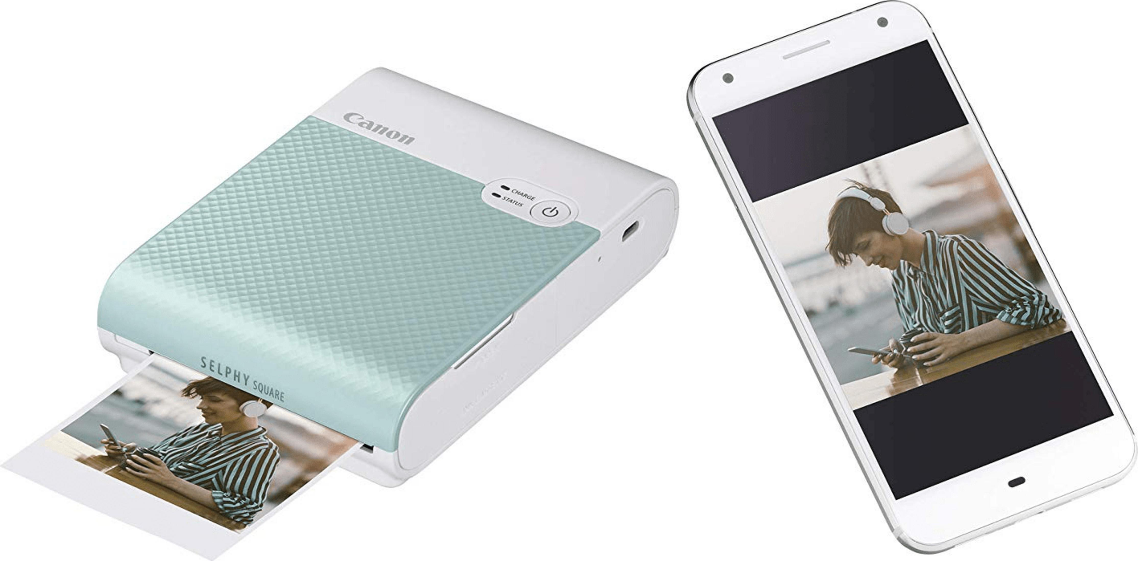 Stampante Canon Selphy Square stampa foto di persona con cuffie accanto a smartphone.