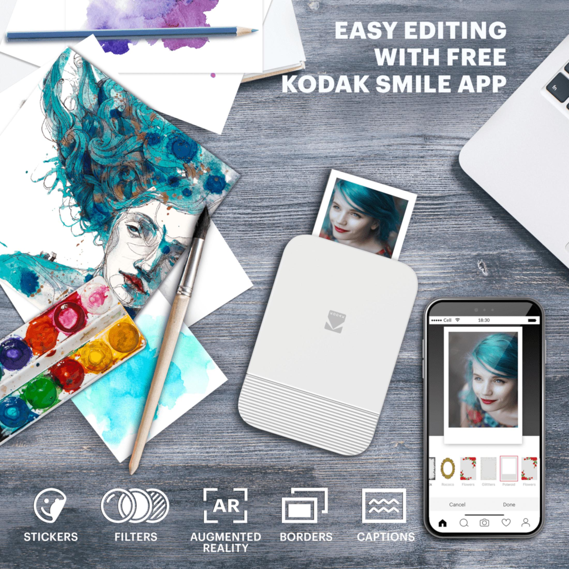 Ein Kodak Smile App Drucker, Handy und Kunstmaterialien auf Holztisch.