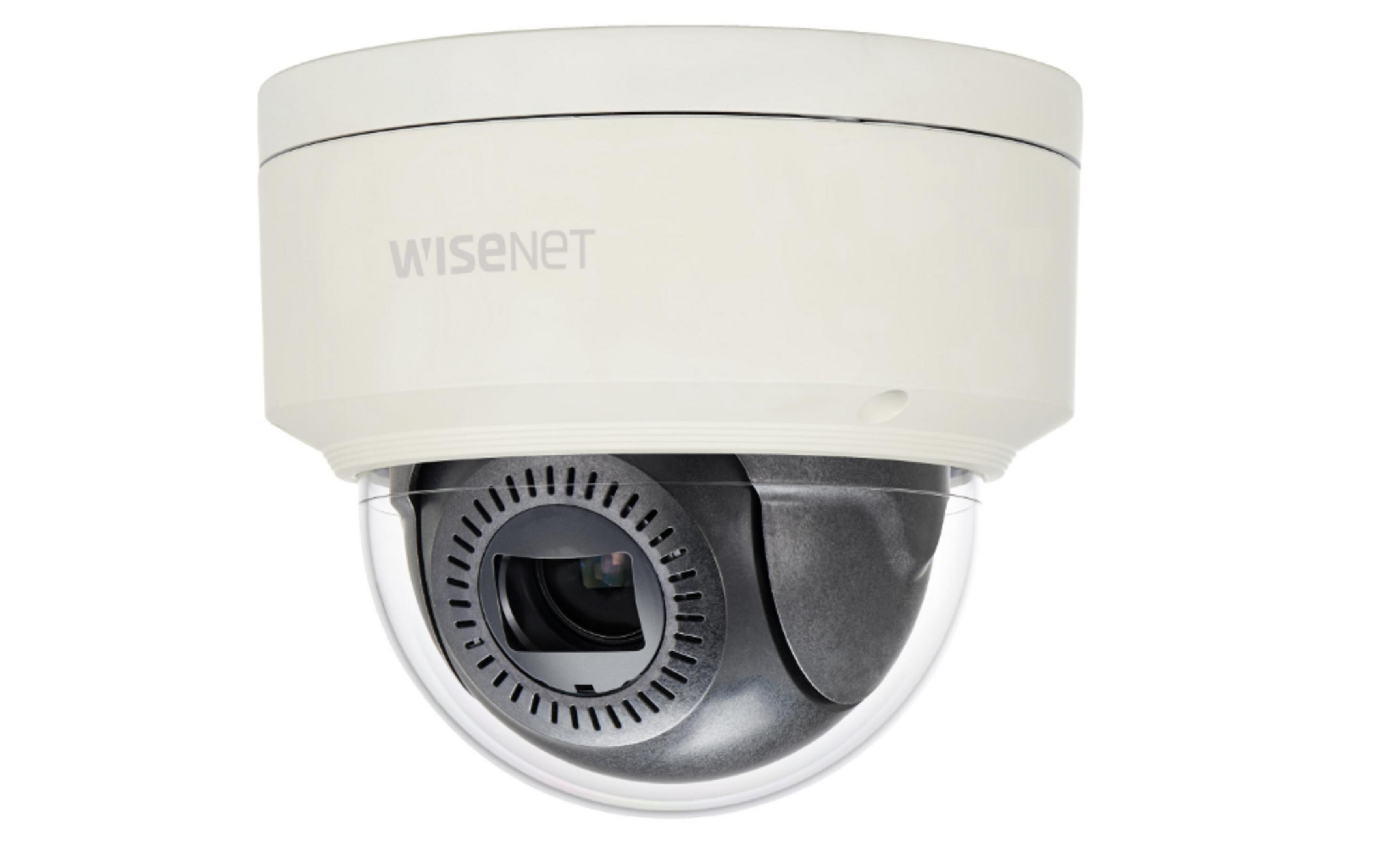 Una telecamera dome bianca con logo 'Wisenet' in alto e copertura trasparente.