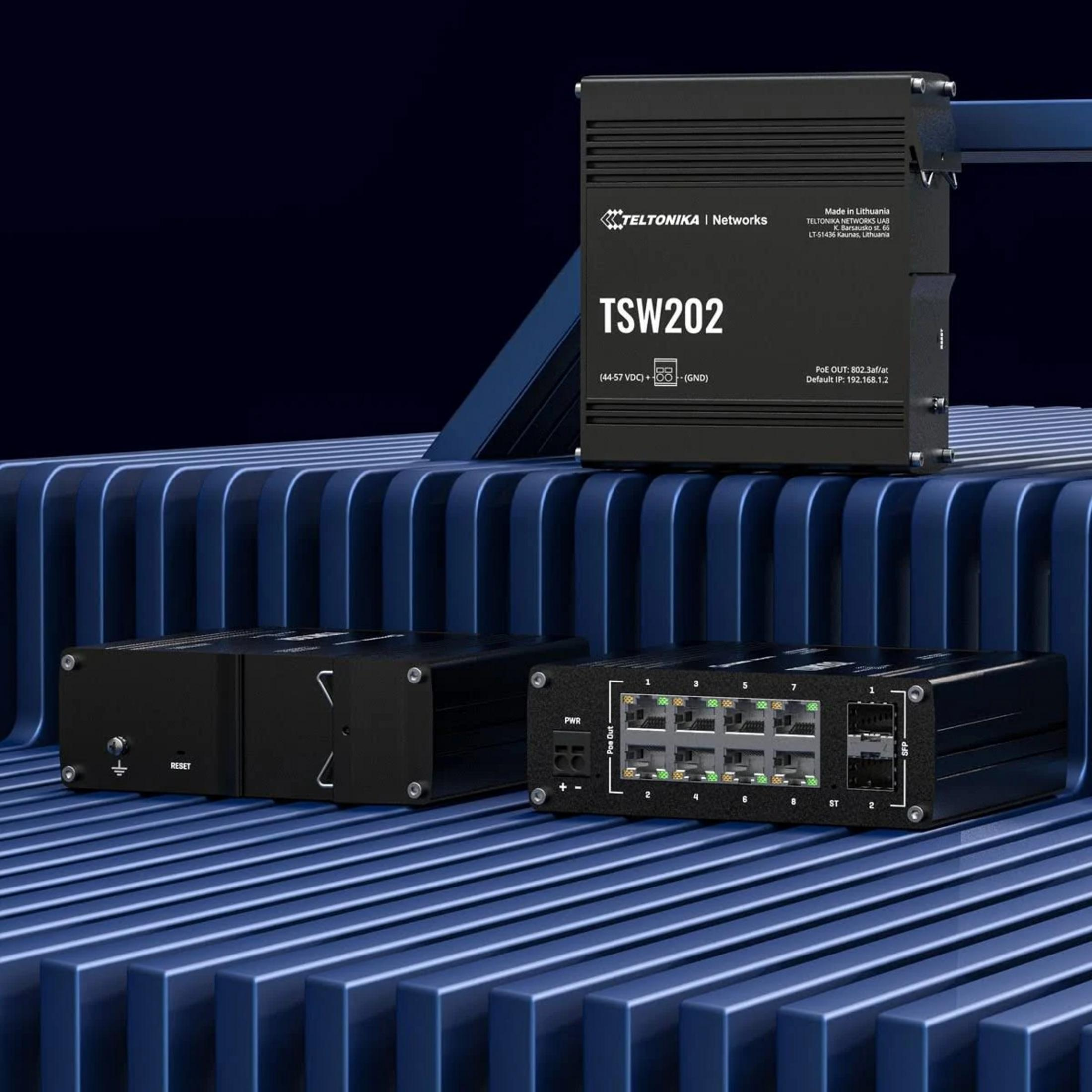 Three black network switches on a blue, ribbed surface.