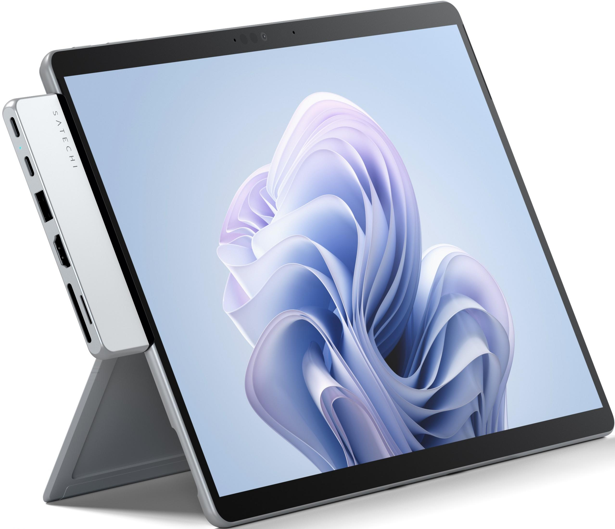 Un hub USB-C argento è collegato a un tablet con uno sfondo astratto viola/blu.