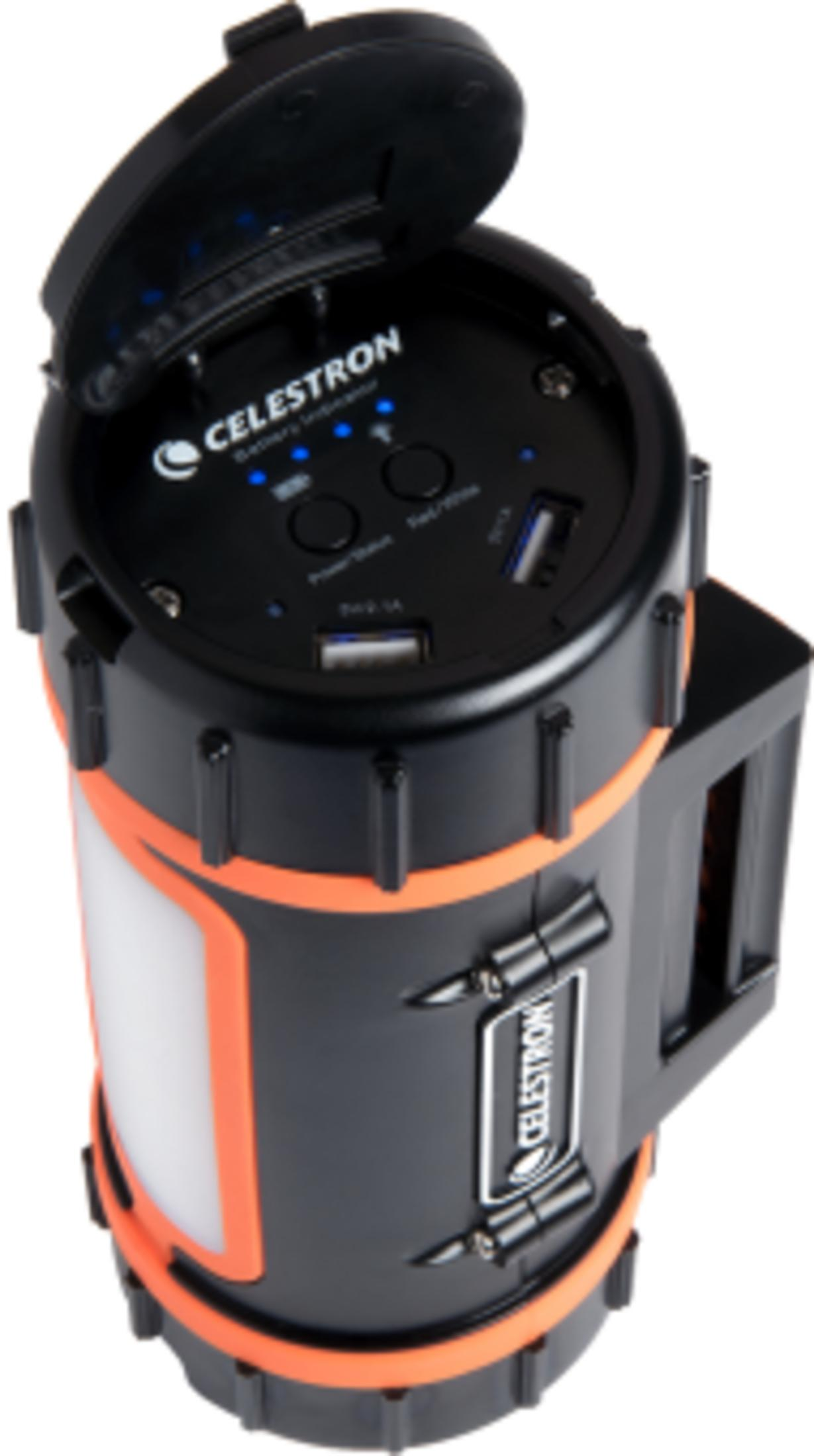 Lanterne noire Celestron avec garniture orange, couvercle ouvert montrant des ports USB et des indicateurs de batterie bleus.