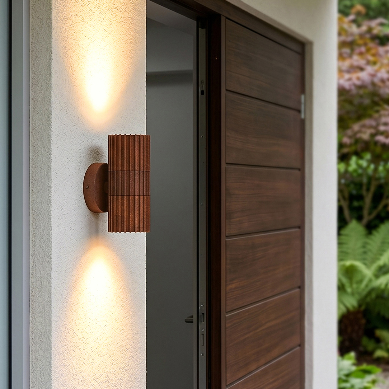 Braune Wandleuchte beleuchtet weiße Wand neben Holztür, Garten im Hintergrund.