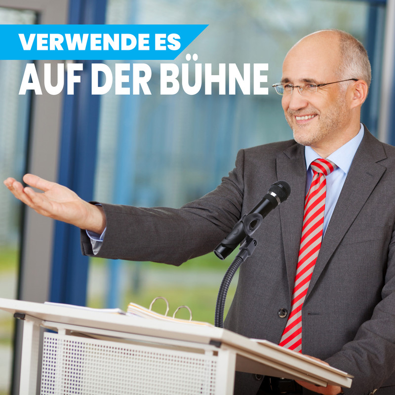 Ein Mann in einem Anzug spricht von einem Podium mit Mikrofon.