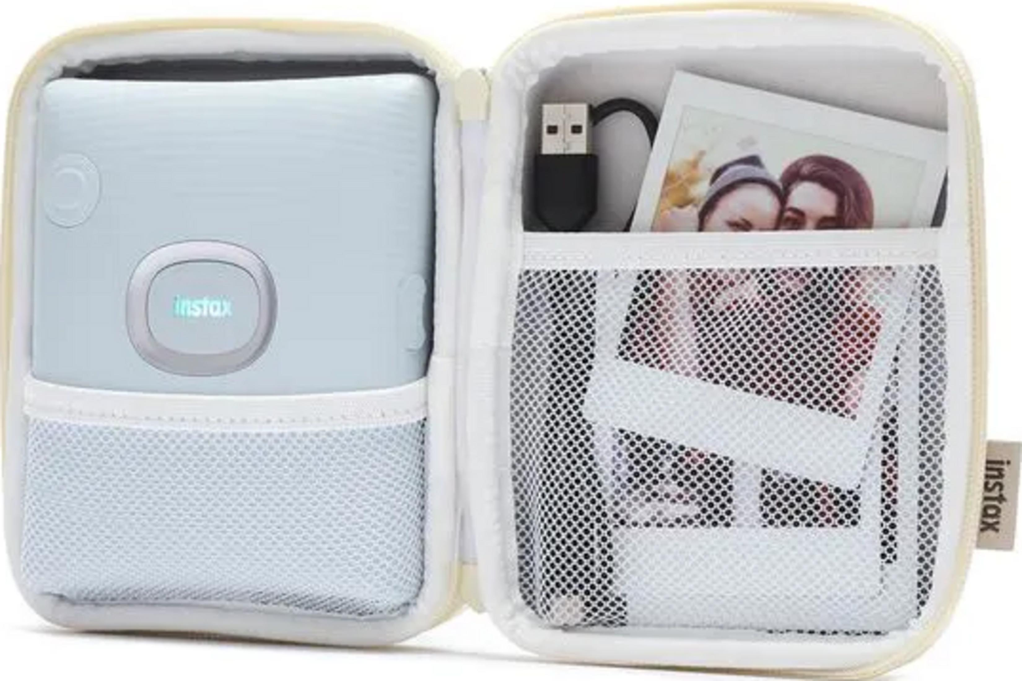 Ein hellblaues Instax-Kameragehäuse mit Fotos und USB-Kabel.