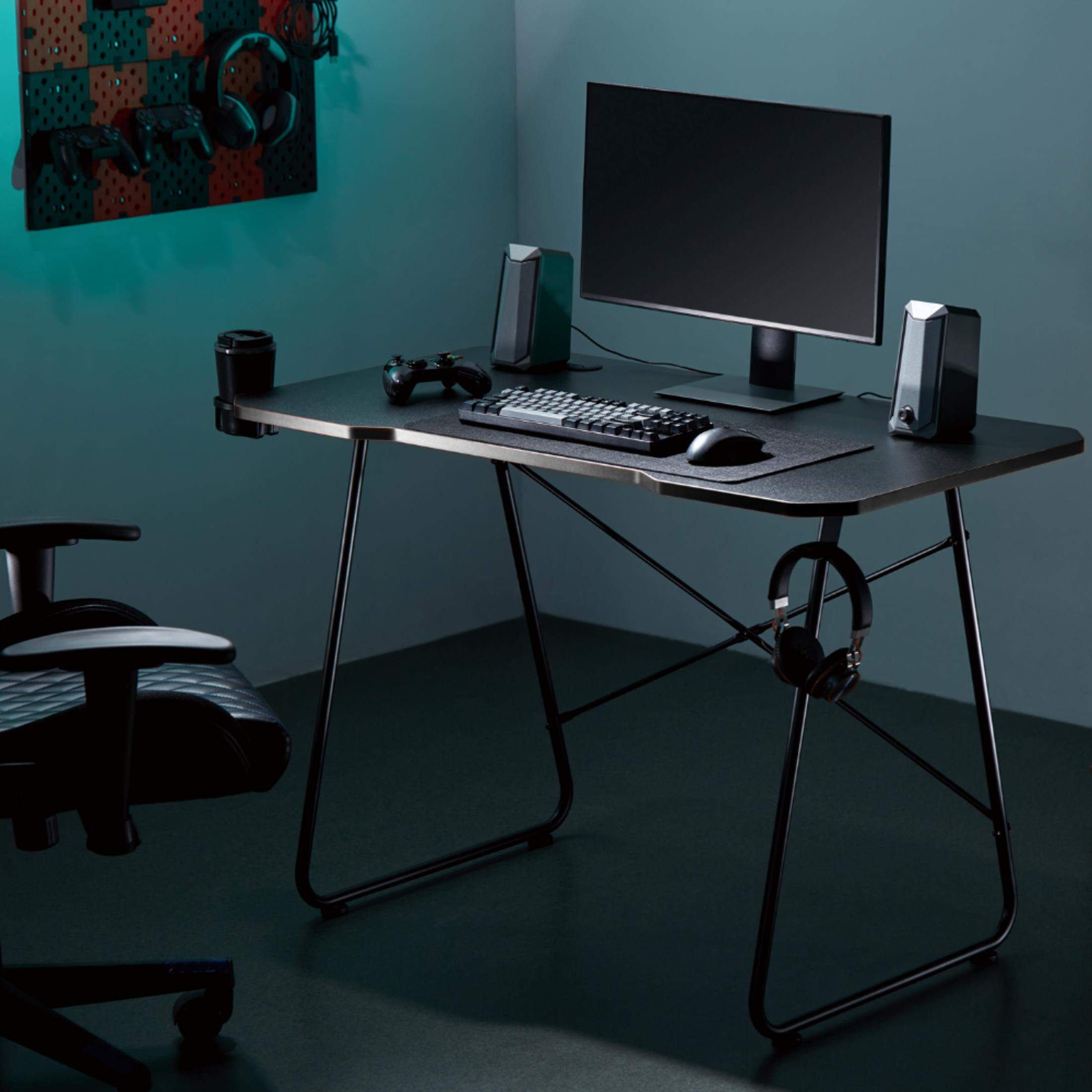 Ein Schreibtisch mit Monitor, Tastatur, Maus, Lautsprechern, Controller und Kopfhörern.