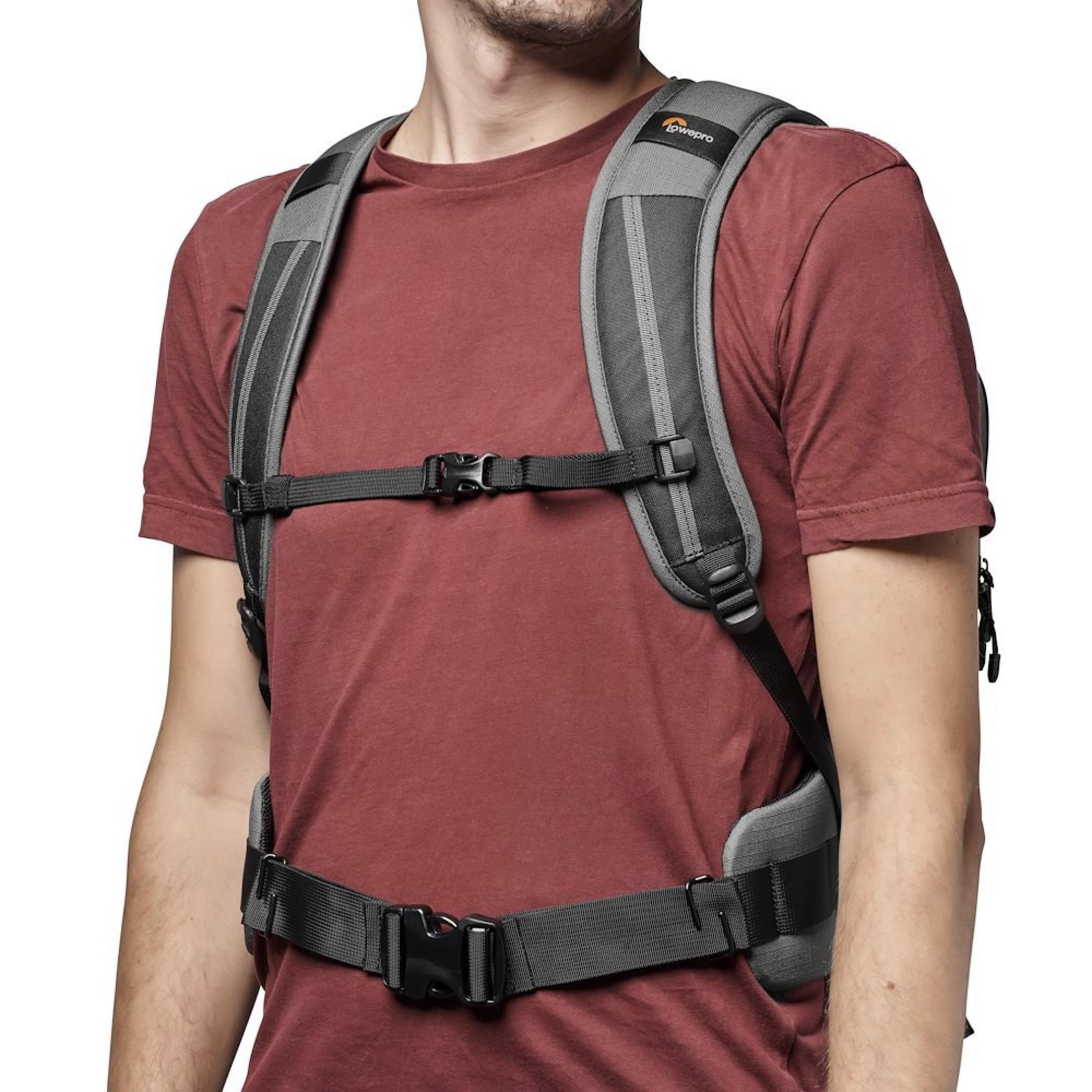Homme en chemise rouge porte un harnais Lowepro gris avec boucles.