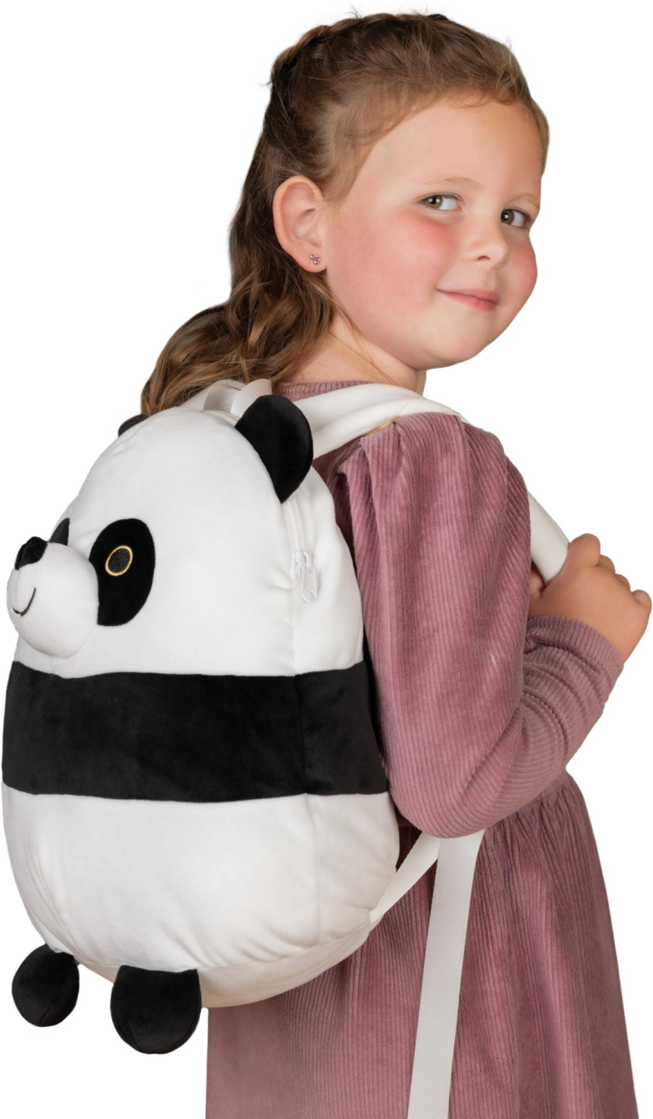 Ein Mädchen mit einem Pandabären-Rucksack aus Plüsch, das in die Kamera lächelt.