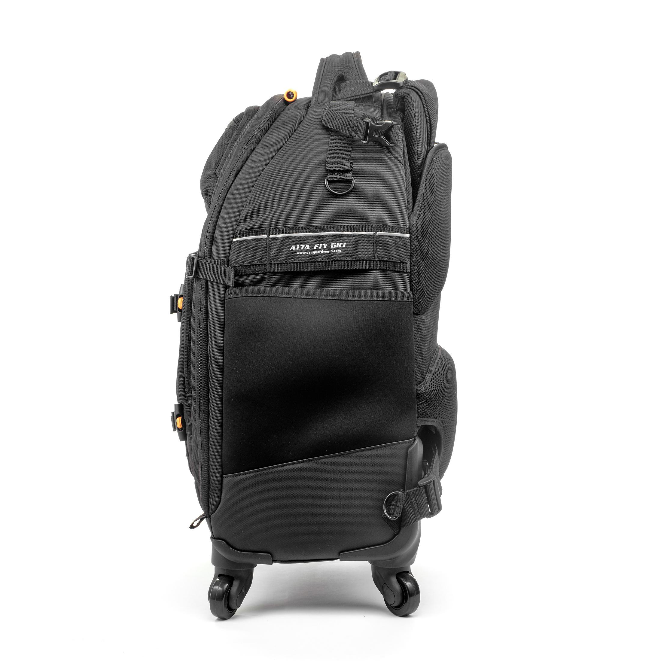 Una mochila negra con ruedas para cámara con múltiples correas y cremalleras sobre fondo blanco.