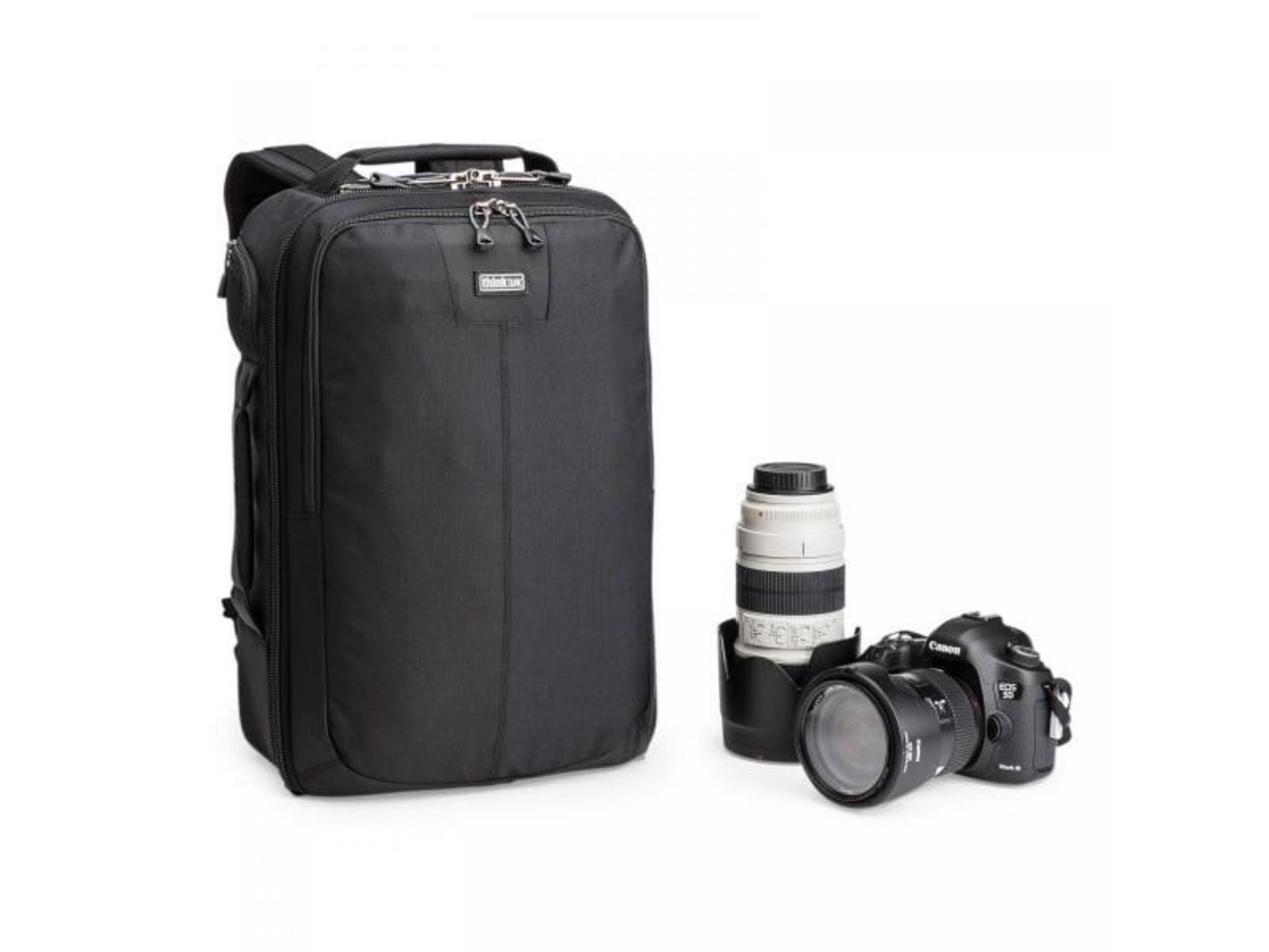 Black backpack with a camera and lens on a white background.