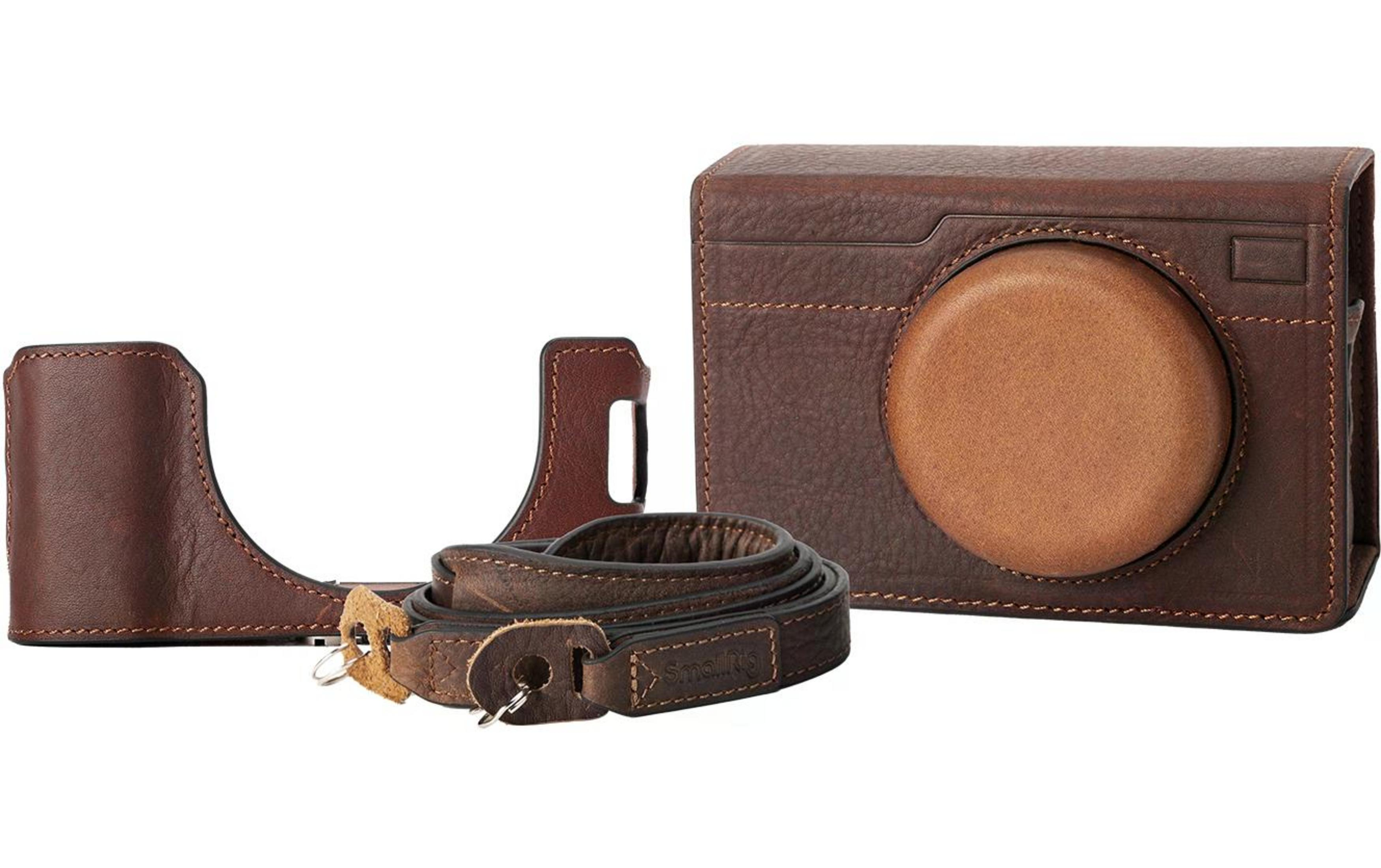 Bruine leren cameratas met riem op witte achtergrond.