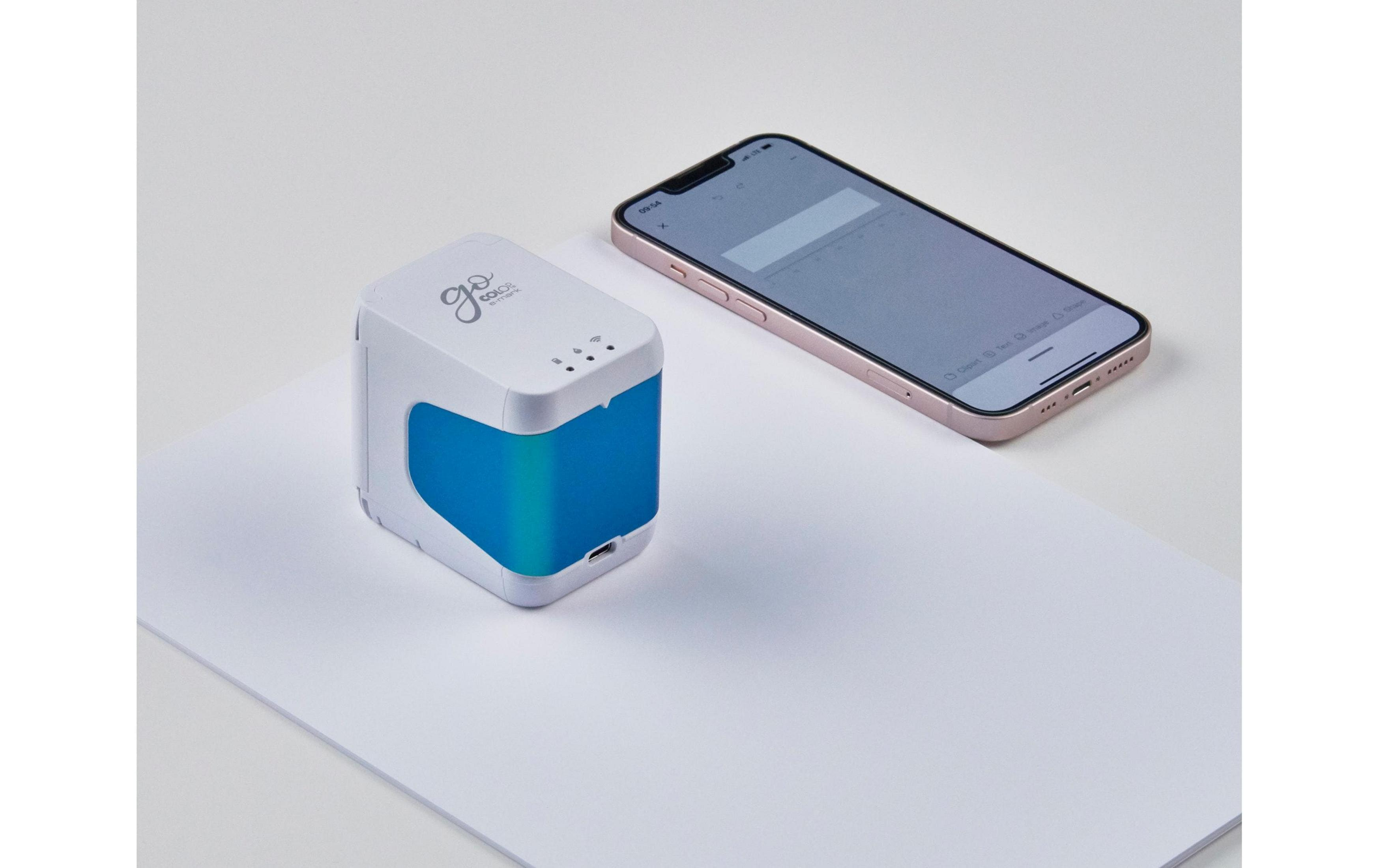 Una stampante bianca con fronte blu accanto a uno smartphone oro rosa su carta bianca.