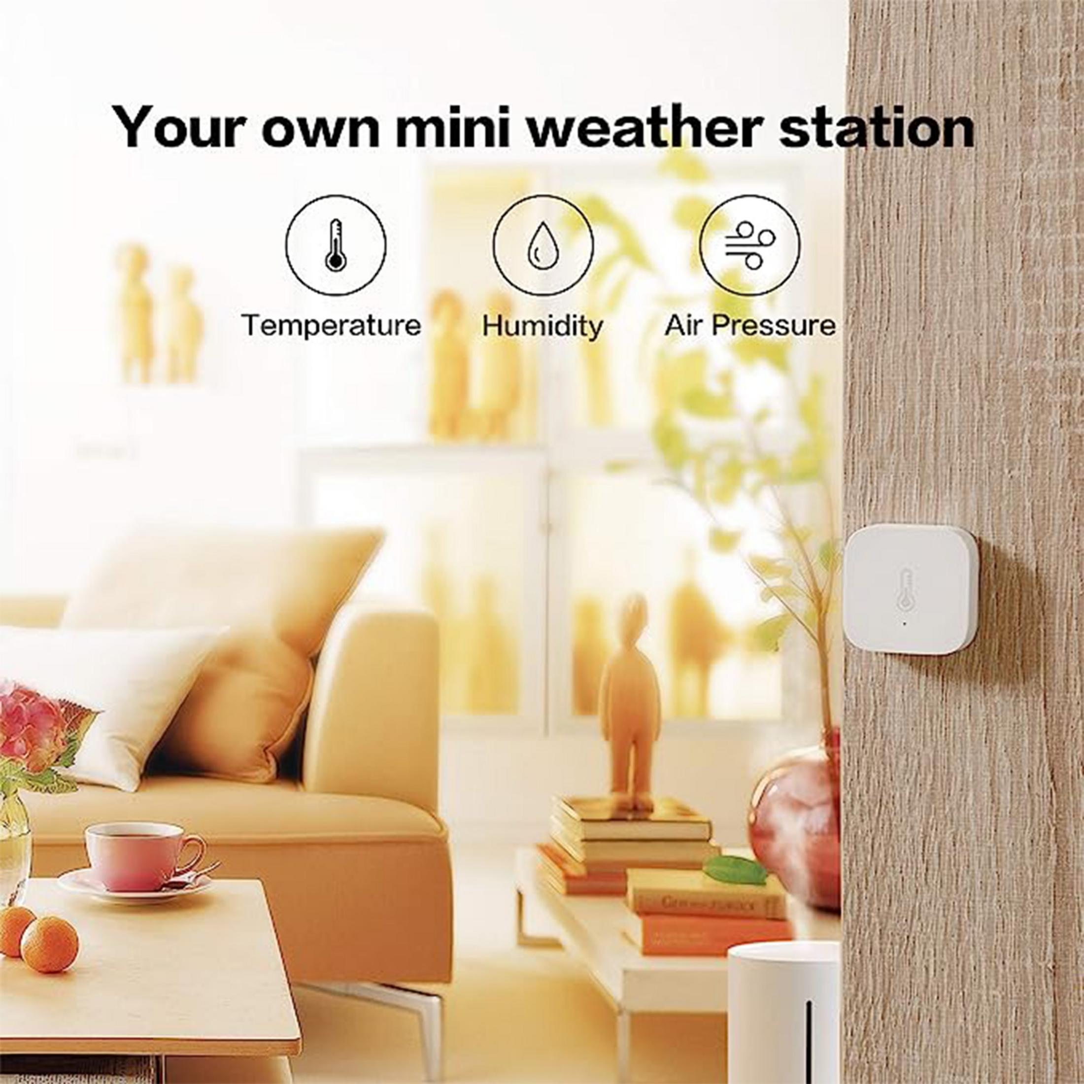 Un dispositivo quadrato bianco con icona termometro su legno.