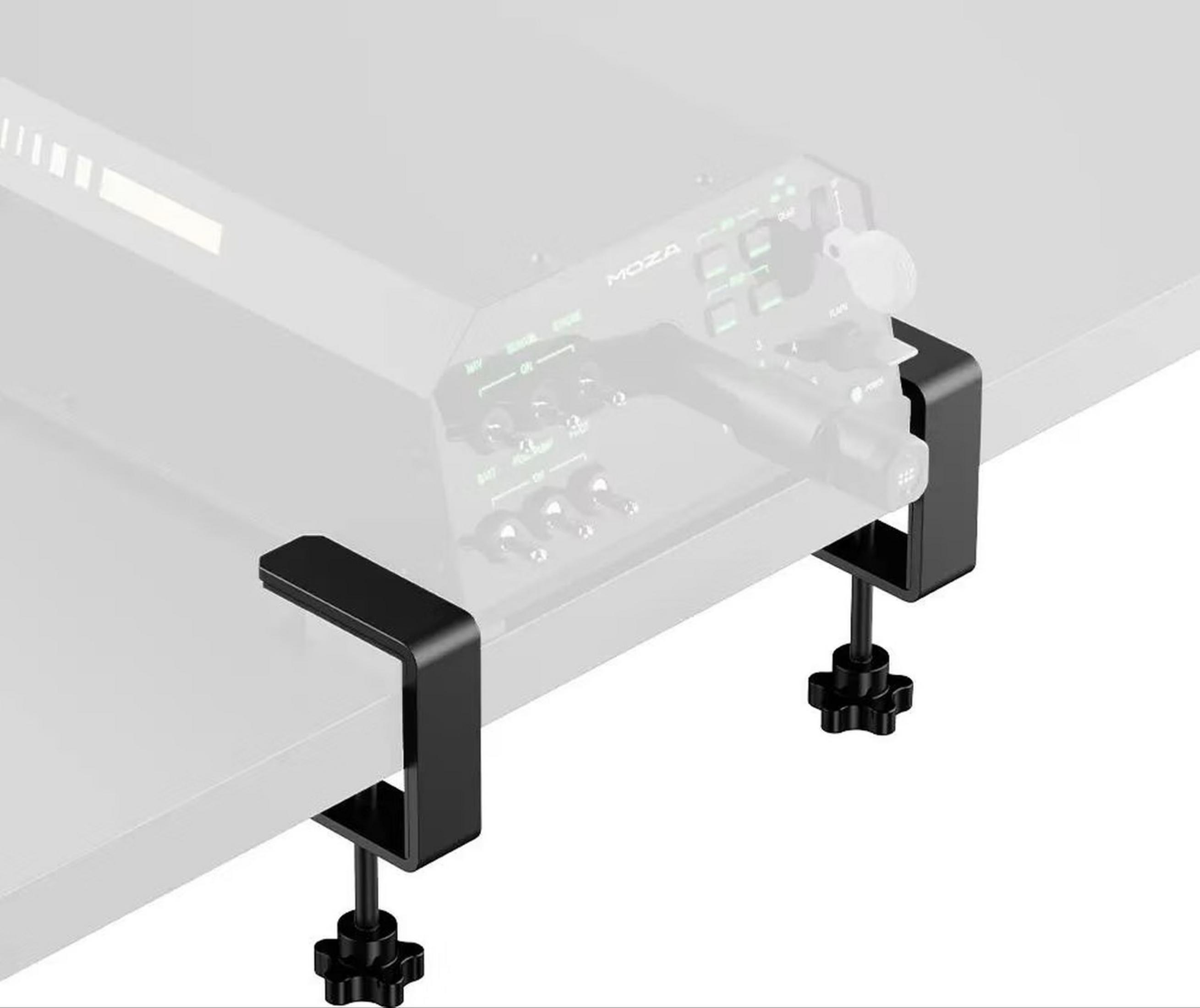 Two black clamps hold a gray device with buttons and a lever on a table.