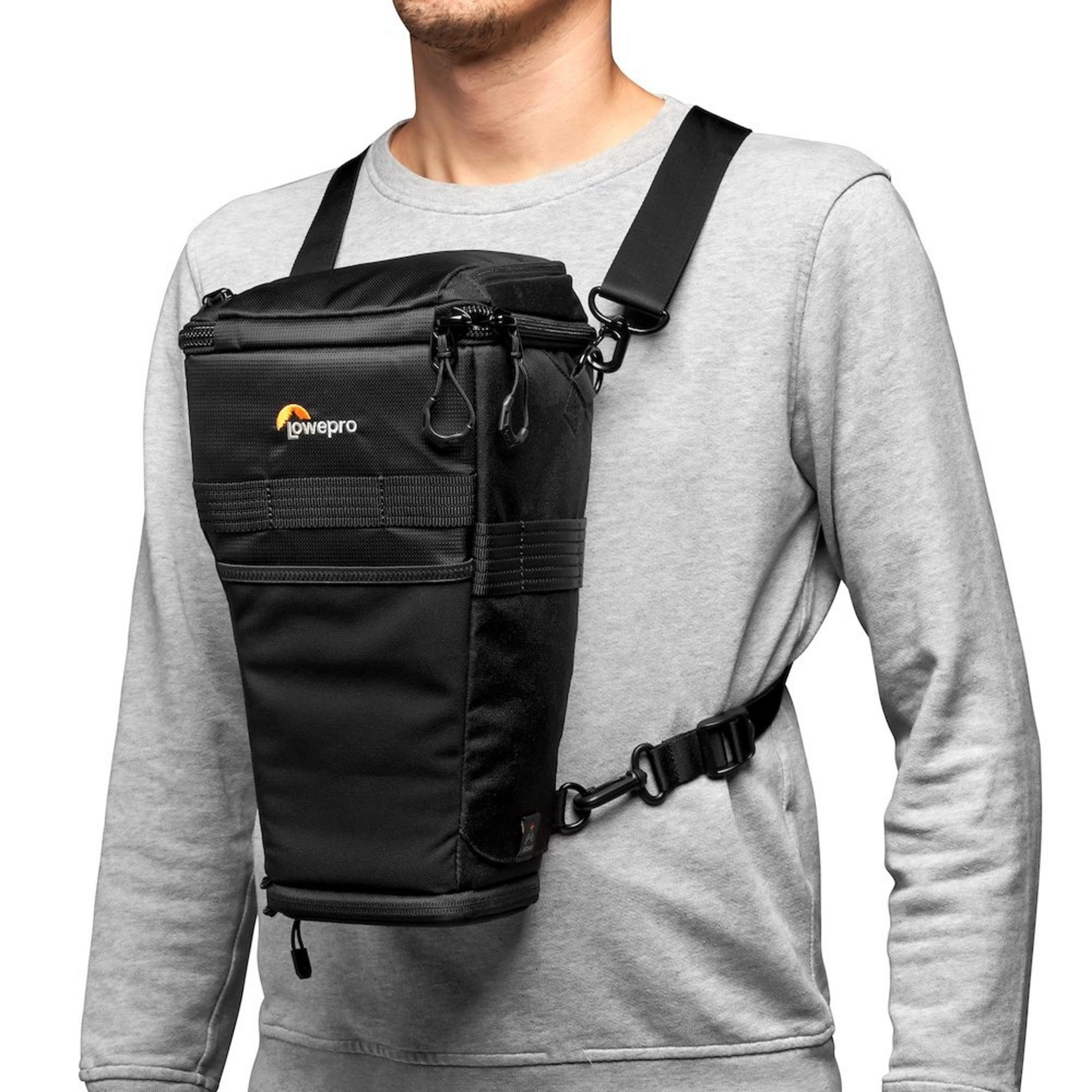 Un uomo indossa una borsa per fotocamera nera sul petto con cinghie.