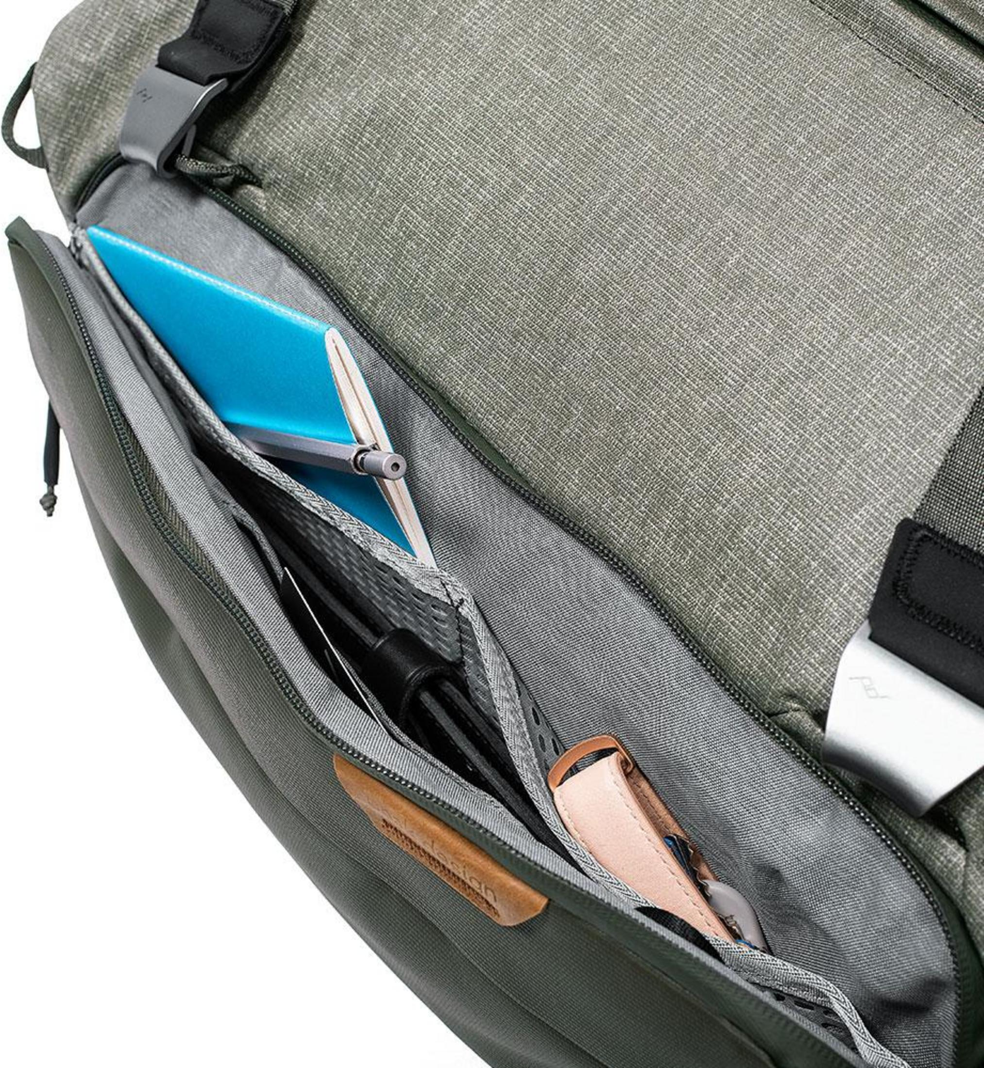 Offene grüne Tasche mit blauer Notiz und Ledergriff.