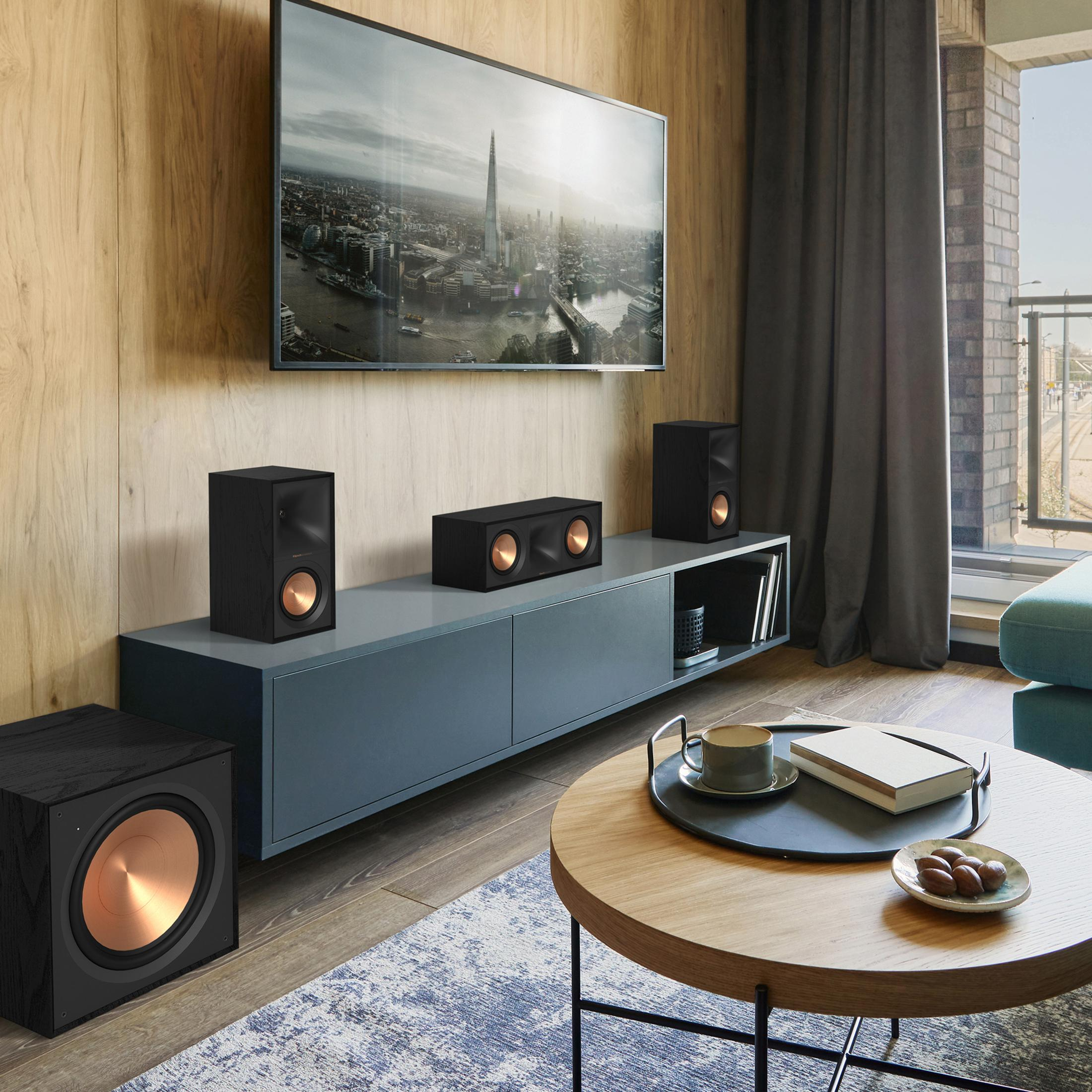 Ein modernes Wohnzimmer mit schwarzen Lautsprechern, einem Subwoofer und einem Fernseher mit Stadtsilhouette.
