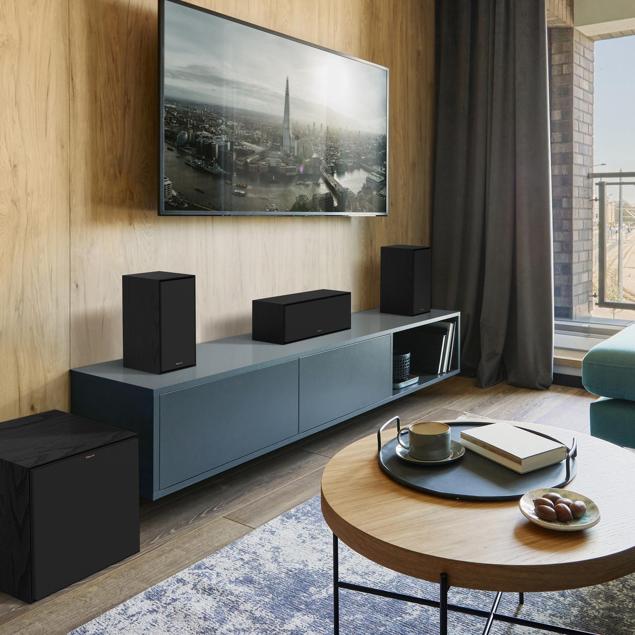 Wohnzimmer mit Holzwand, Fernseher, Lautsprechern und Couchtisch.