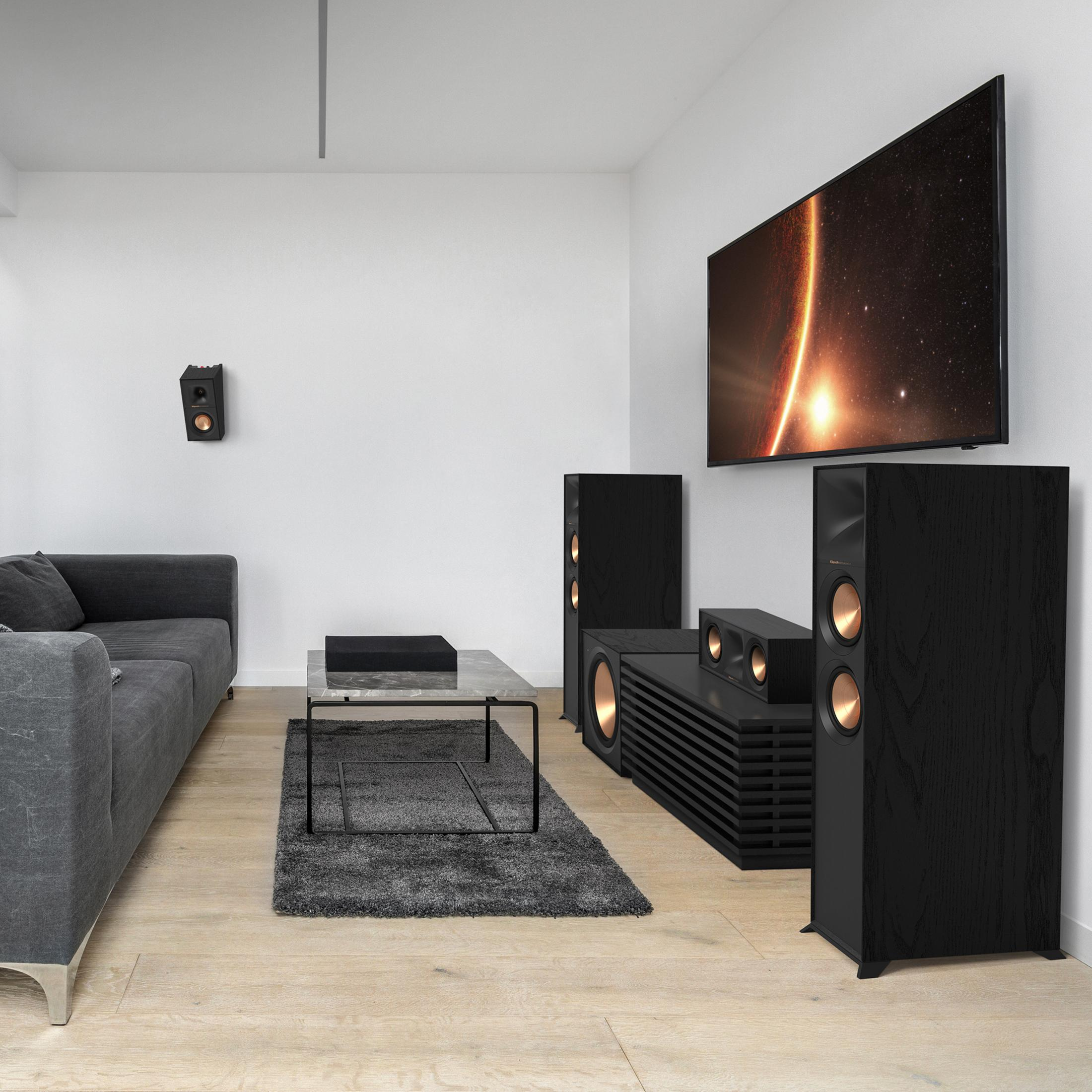 Ein modernes Wohnzimmer mit dunklen Lautsprechern, Sofa, Couchtisch und Fernseher.