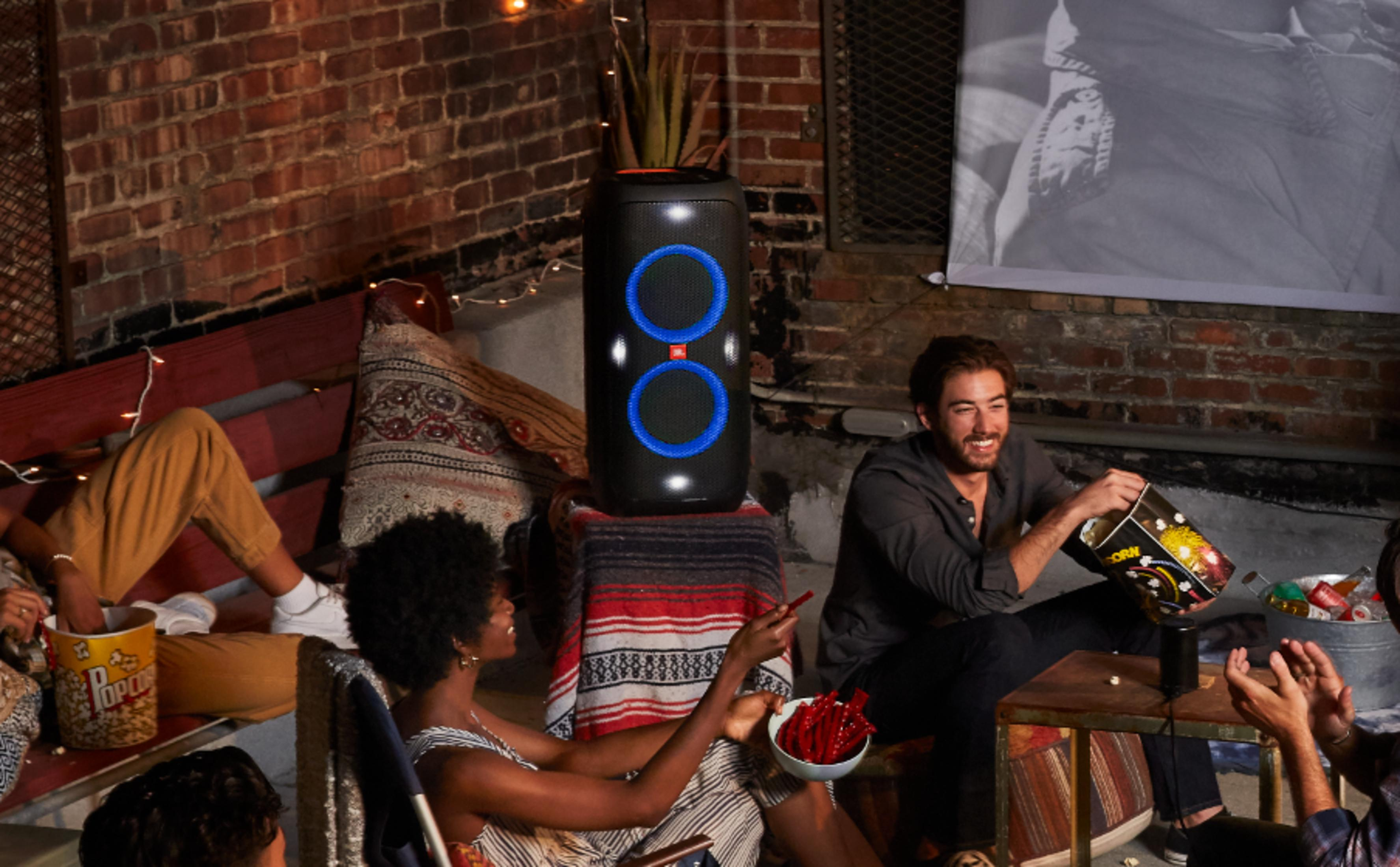 Amici si godono una serata cinema con popcorn e altoparlante JBL.